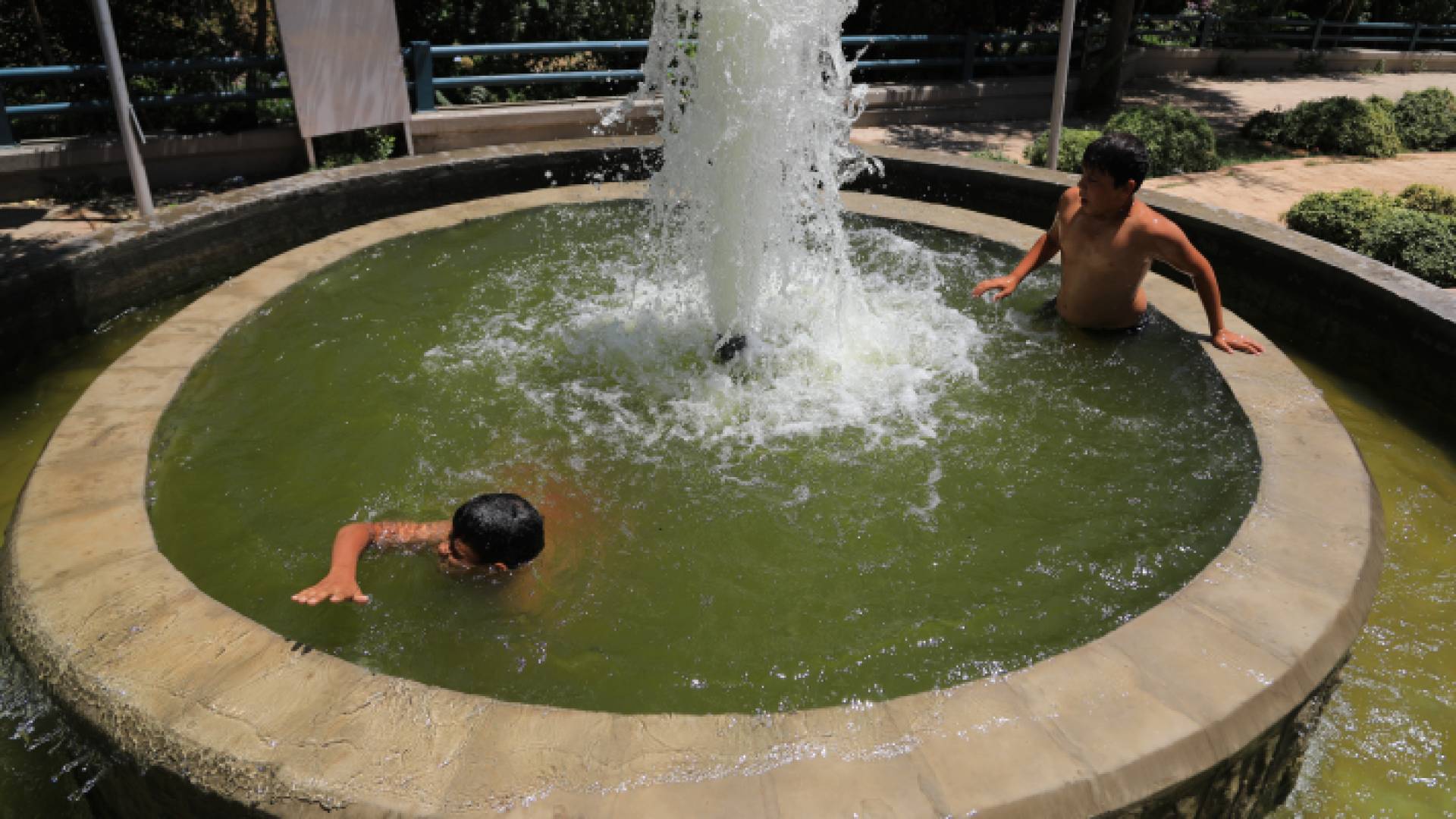 أطفال يهربون من موجة الحر باللعب فى الماء