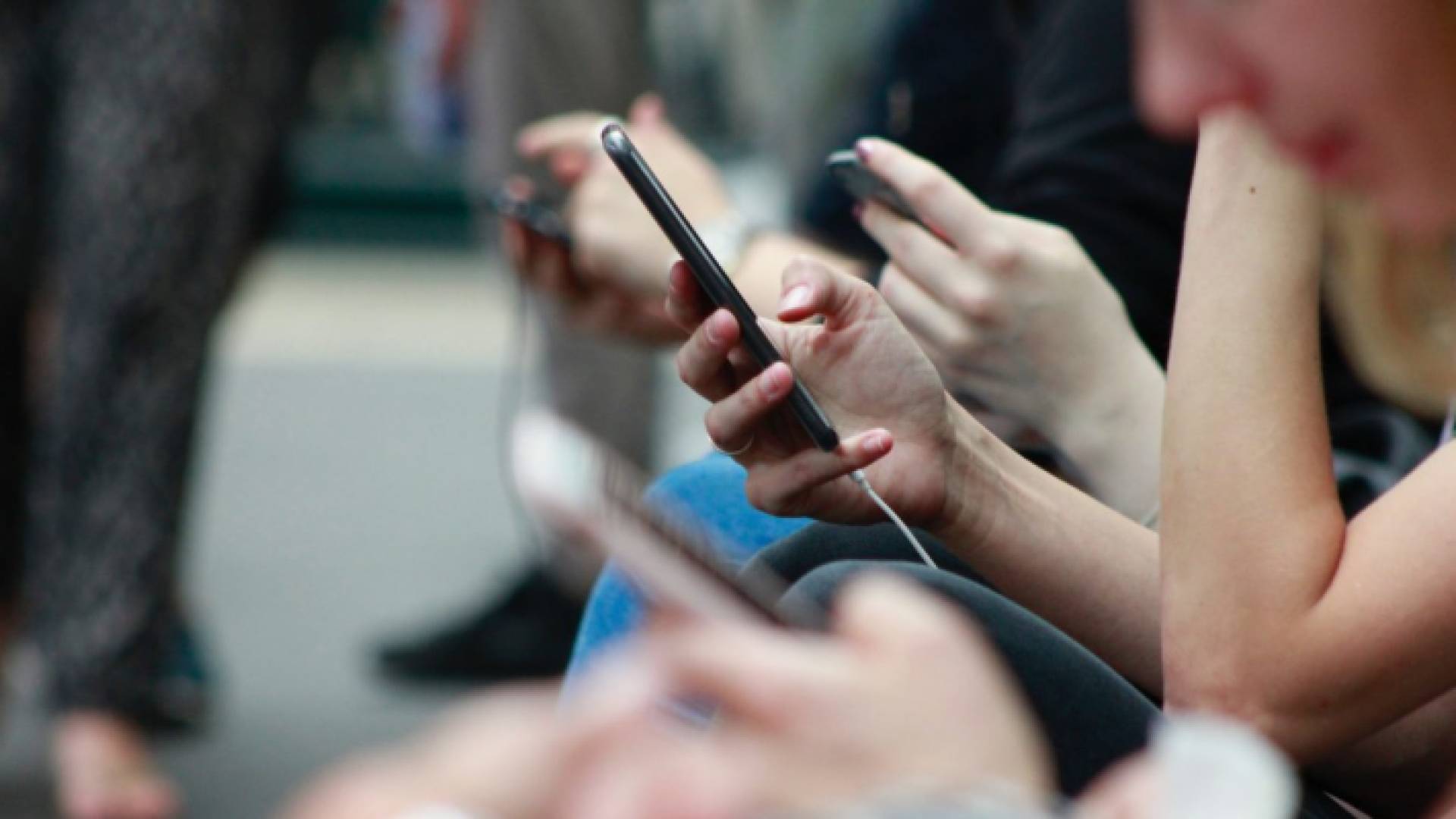 أشخاص يحملون هواتف محمولة - تعبيرية