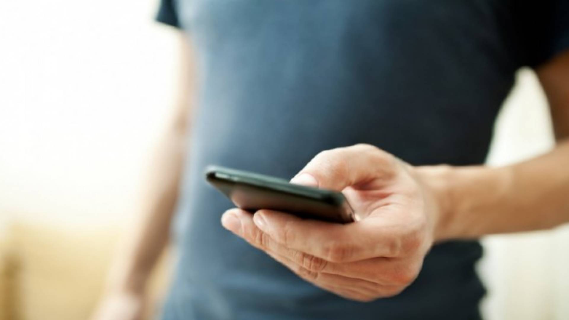 شاب يستخدم هاتفه الخلوي - تعبيرية