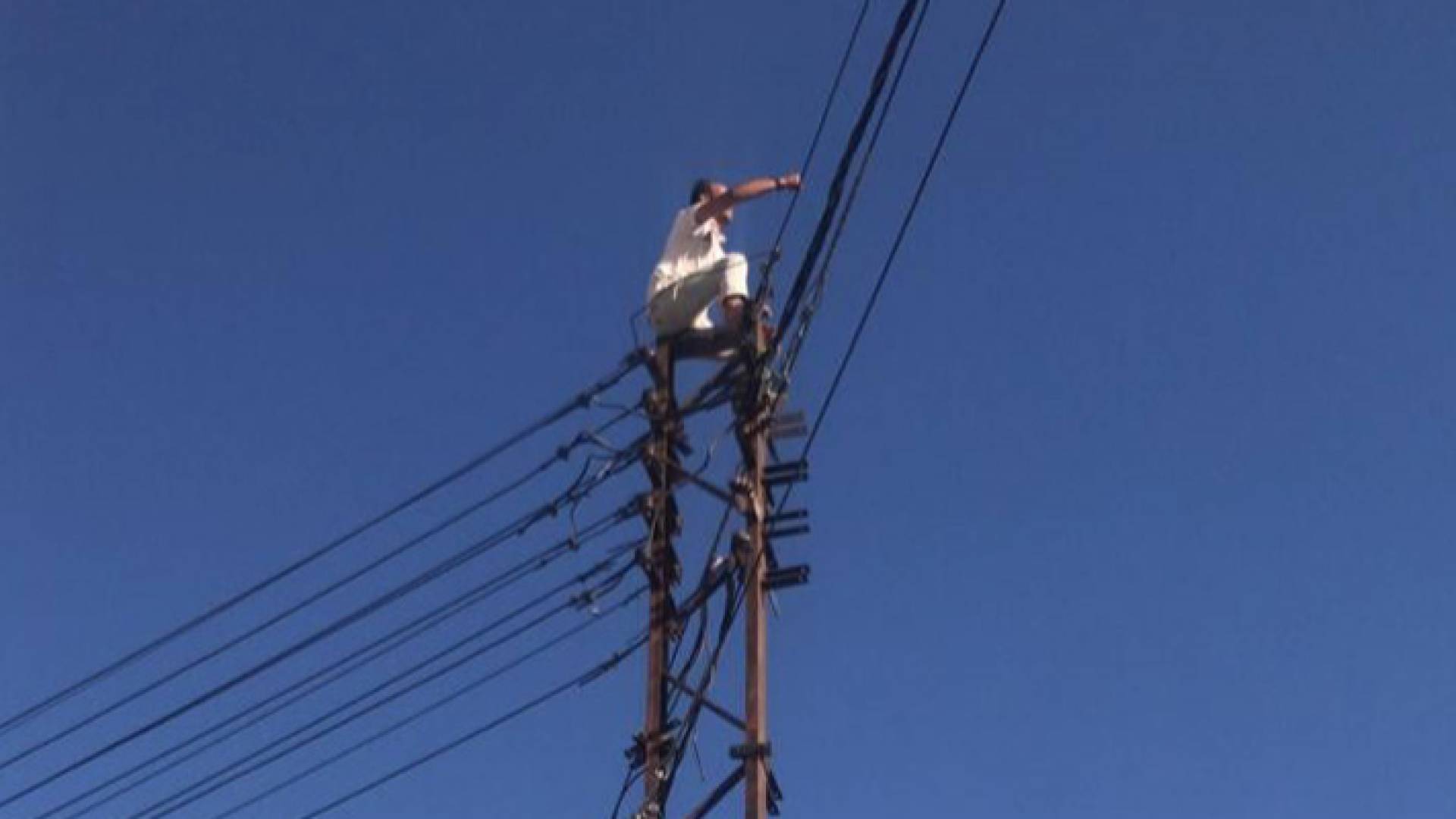 ثلاثيني يحاول إلقاء نفسه من أعلى عمود كهرباء