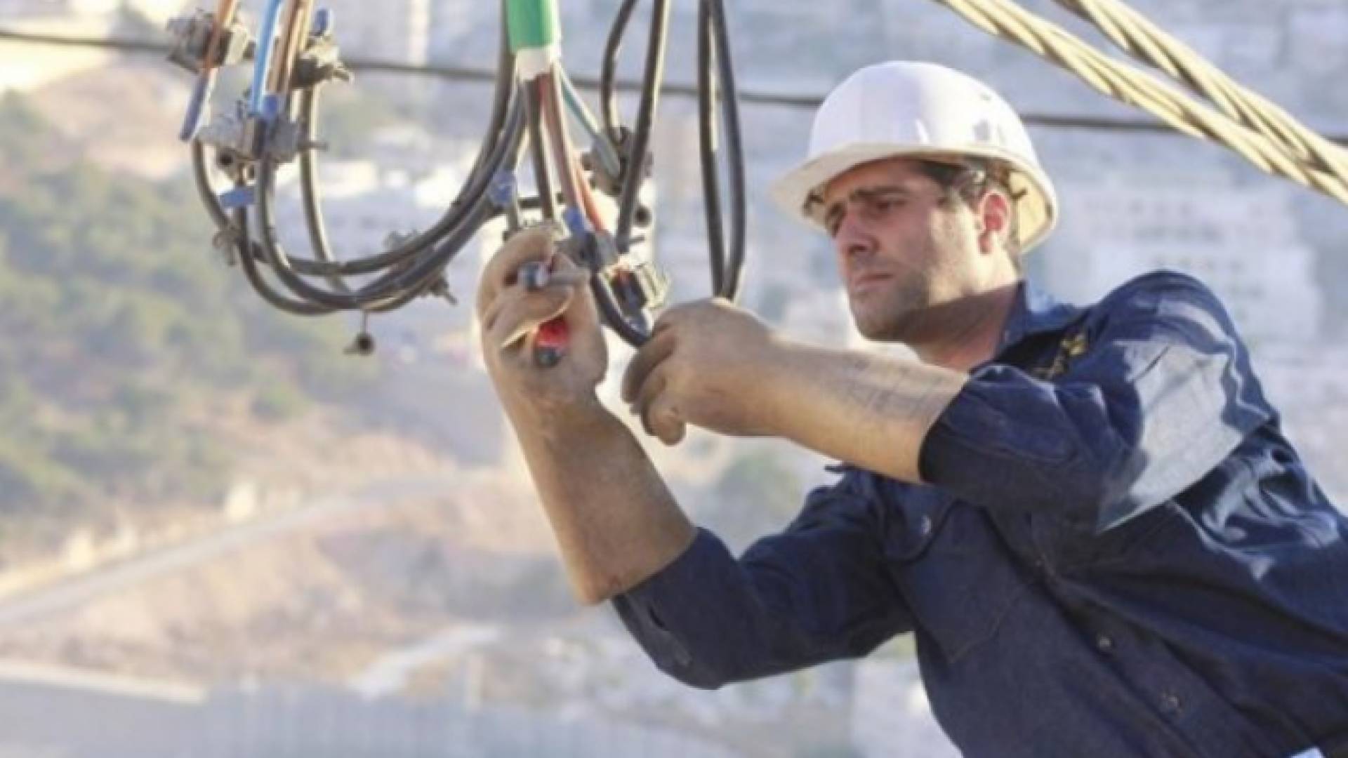 مهندس يجري إصلاحا على أحد خطوط التيار الكهربائي