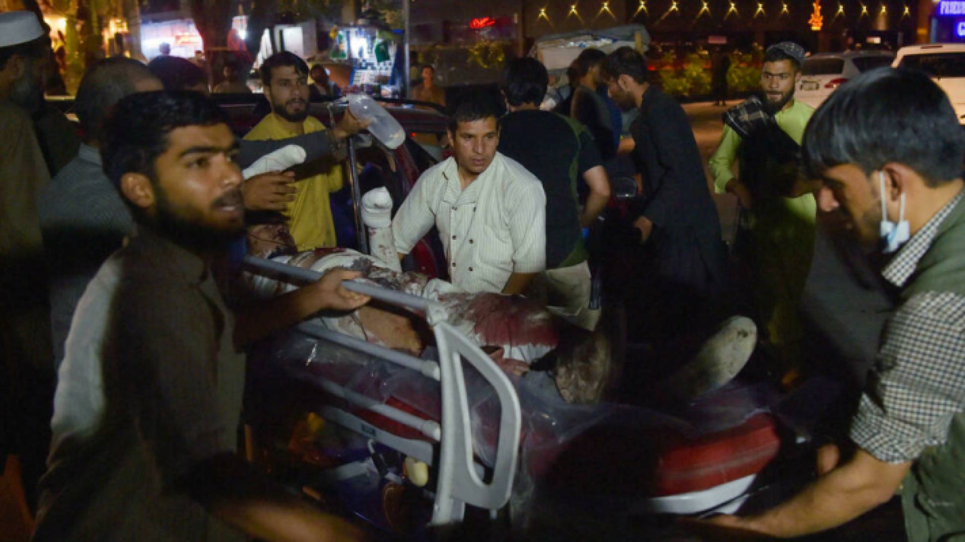 عاملون صحيون ينقلون مصابا على نقالة إلى مستشفى بعد هجوم انتحاري مزدوج في مطار كابول