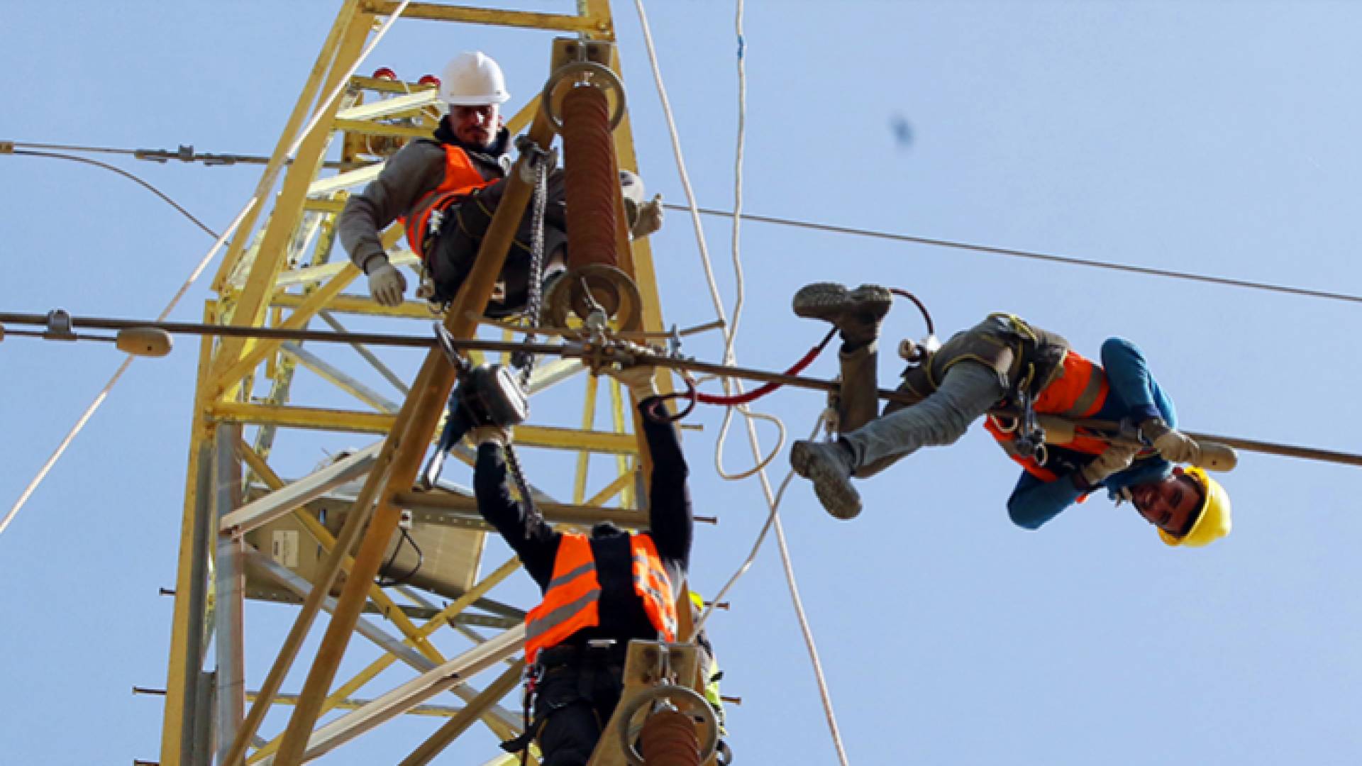عمال كهرباء ينفذون أعمال صيانة للخطوط - أرشيفية