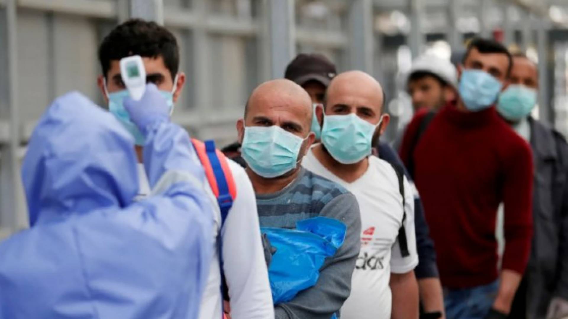 عامل في الكوادر الصحية يتحقق من درجة حرارة أشخاص - أرشيفية