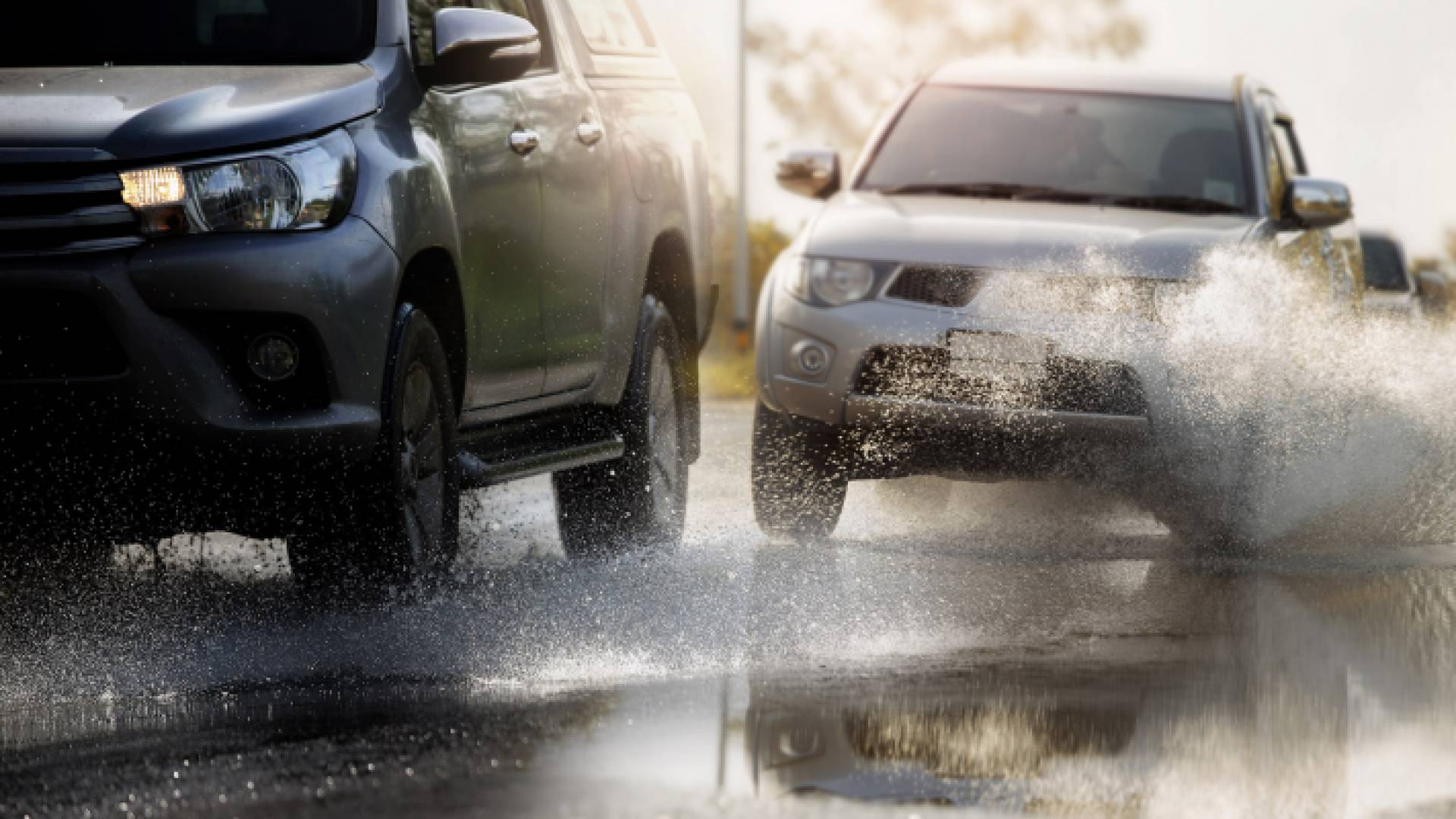 مركبتان تسيران على طريق مبللة بفعل تساقط الأمطار - تعبيرية