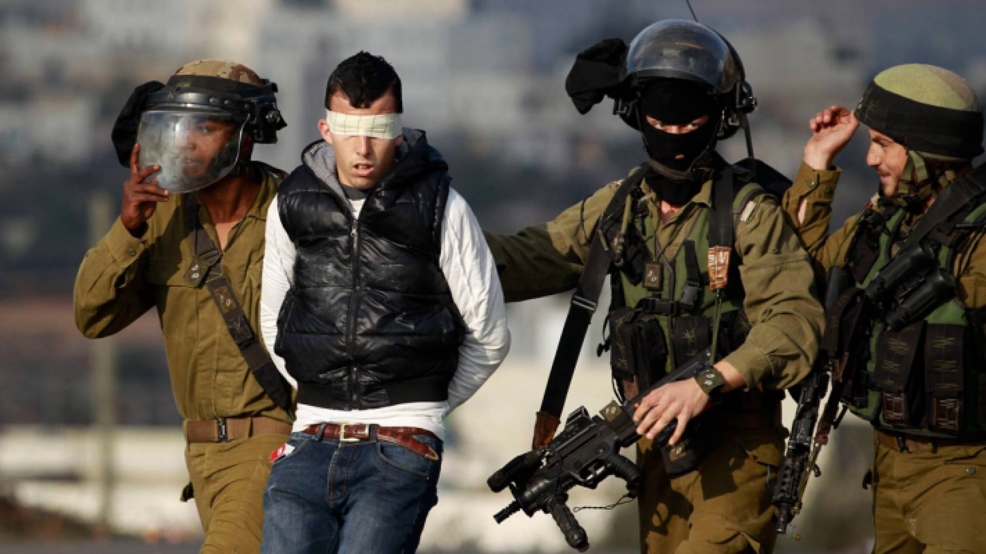 عناصر من قوات الاحتلال الإسرائيلي تعتقل شابا فلسطينيا - أرشيفية