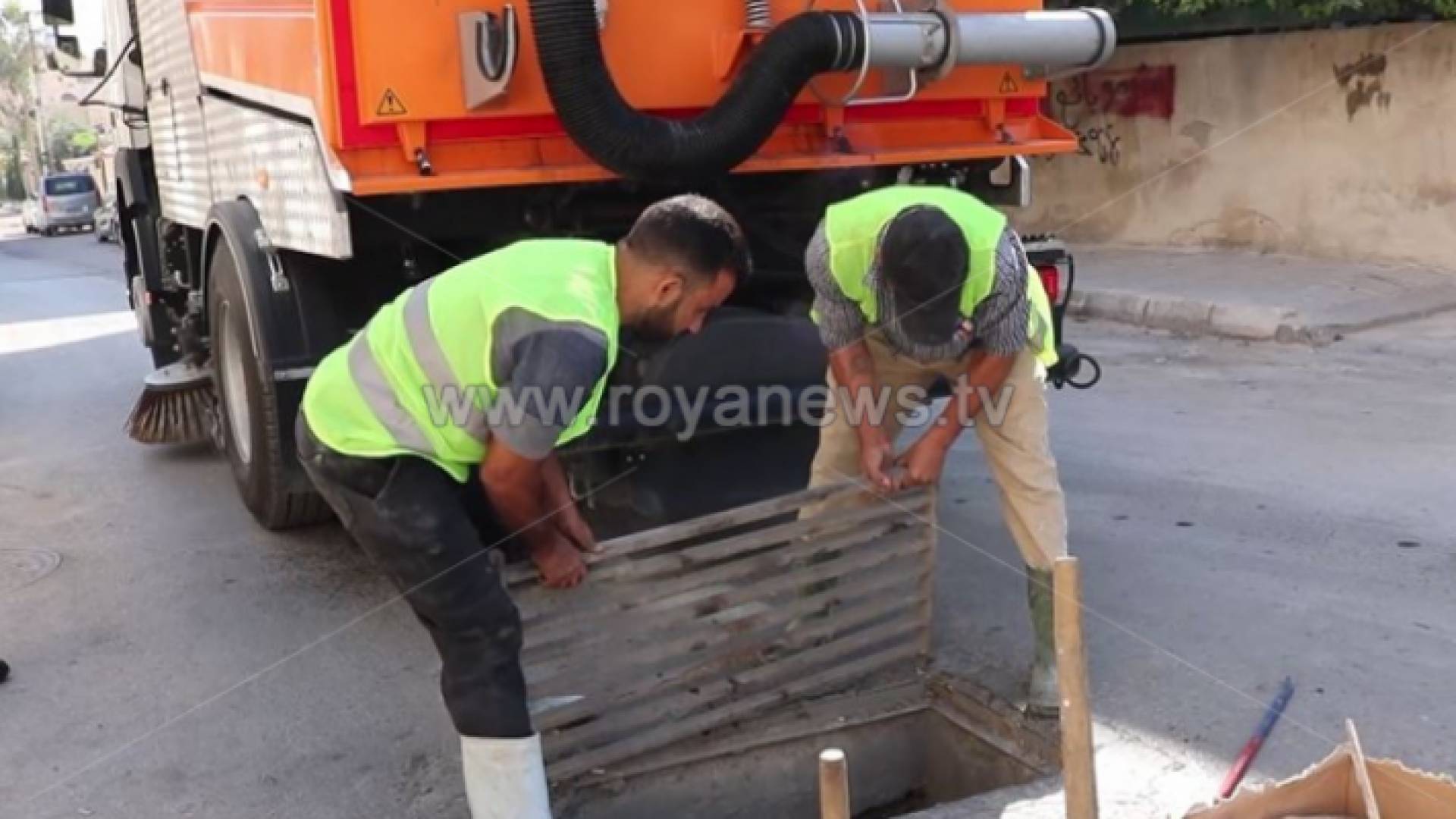 عمال يتأكدون من نظافة إحدى قنوات تصريف مياه الأمطار في الزرقاء