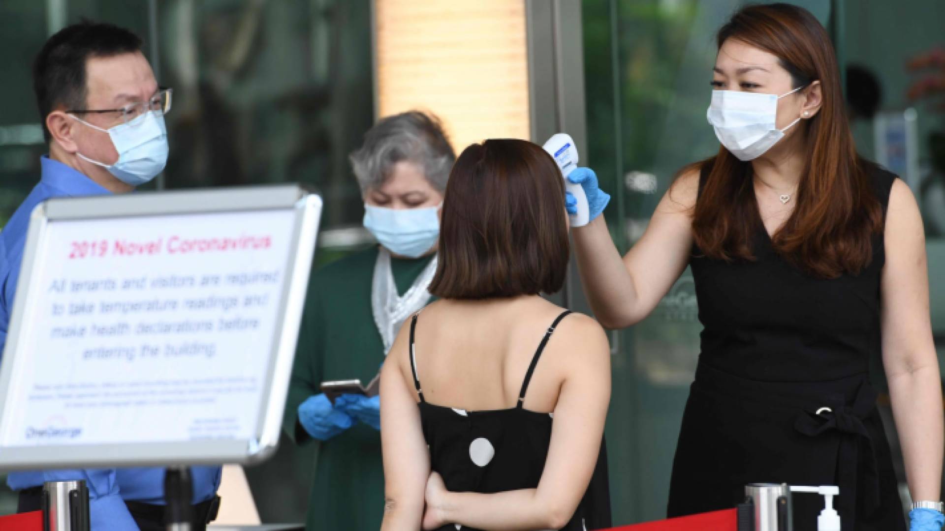 خلال إجراء فحص درجة الحرارة لإحدى السيدات في سنغافورة