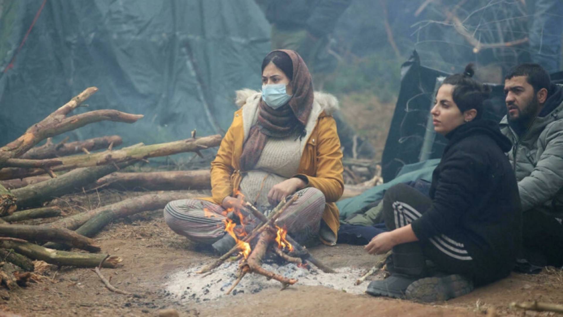 مهاجرون في مخيم للاجئين على الحدود بين بيلاروسيا وبولندا في منطقة غرودنو. (أ.ف.ب)