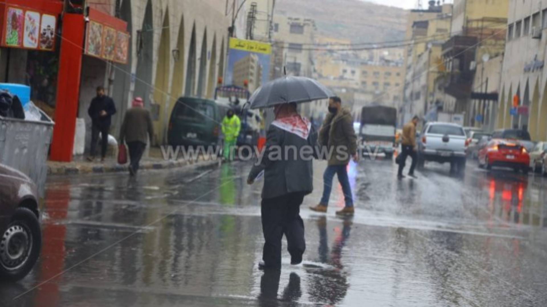 مسن يحمل مظلة تحت الأمطار - أرشيفية