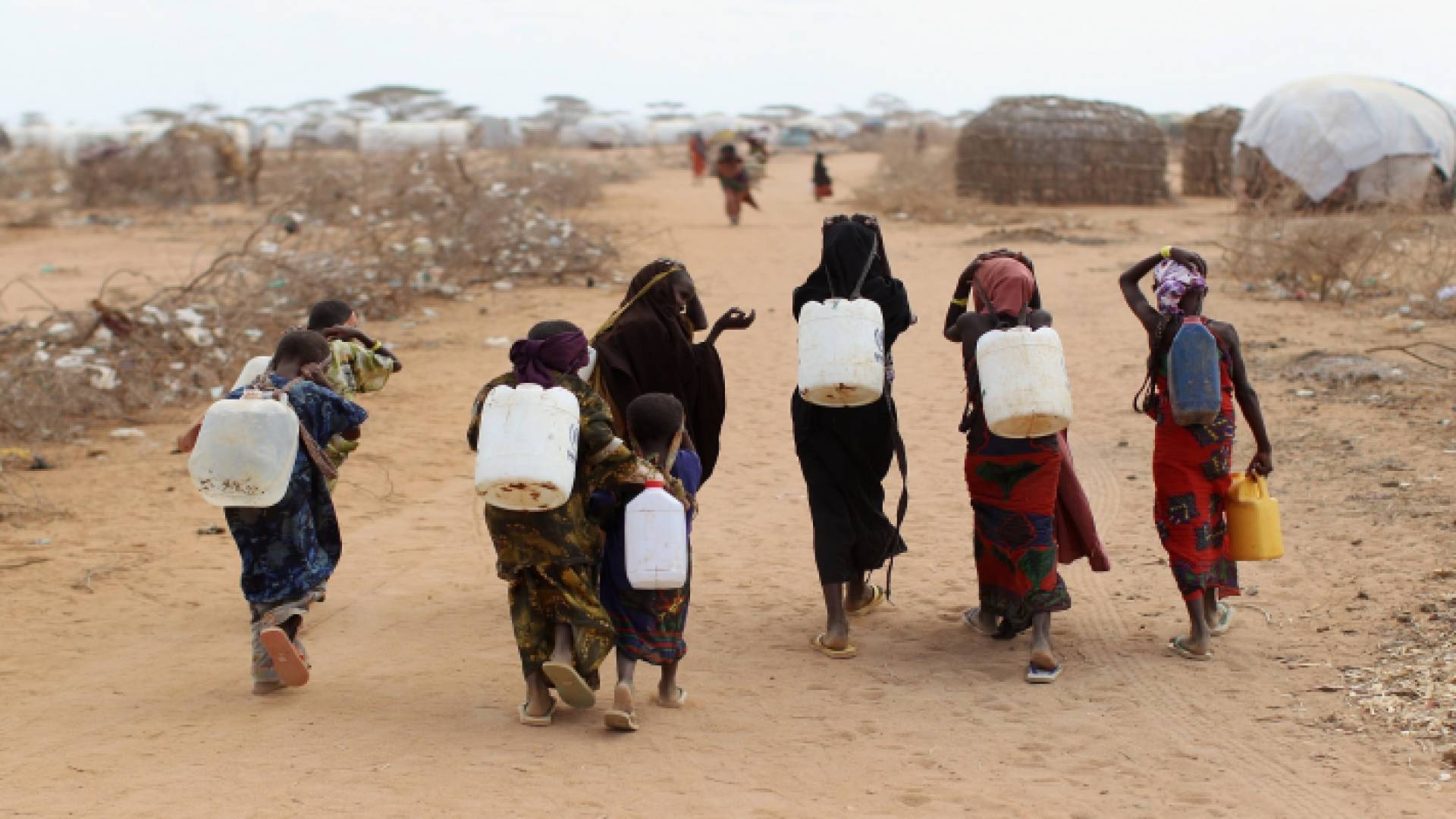 أطفال يحملون جالونات مياه فارغة