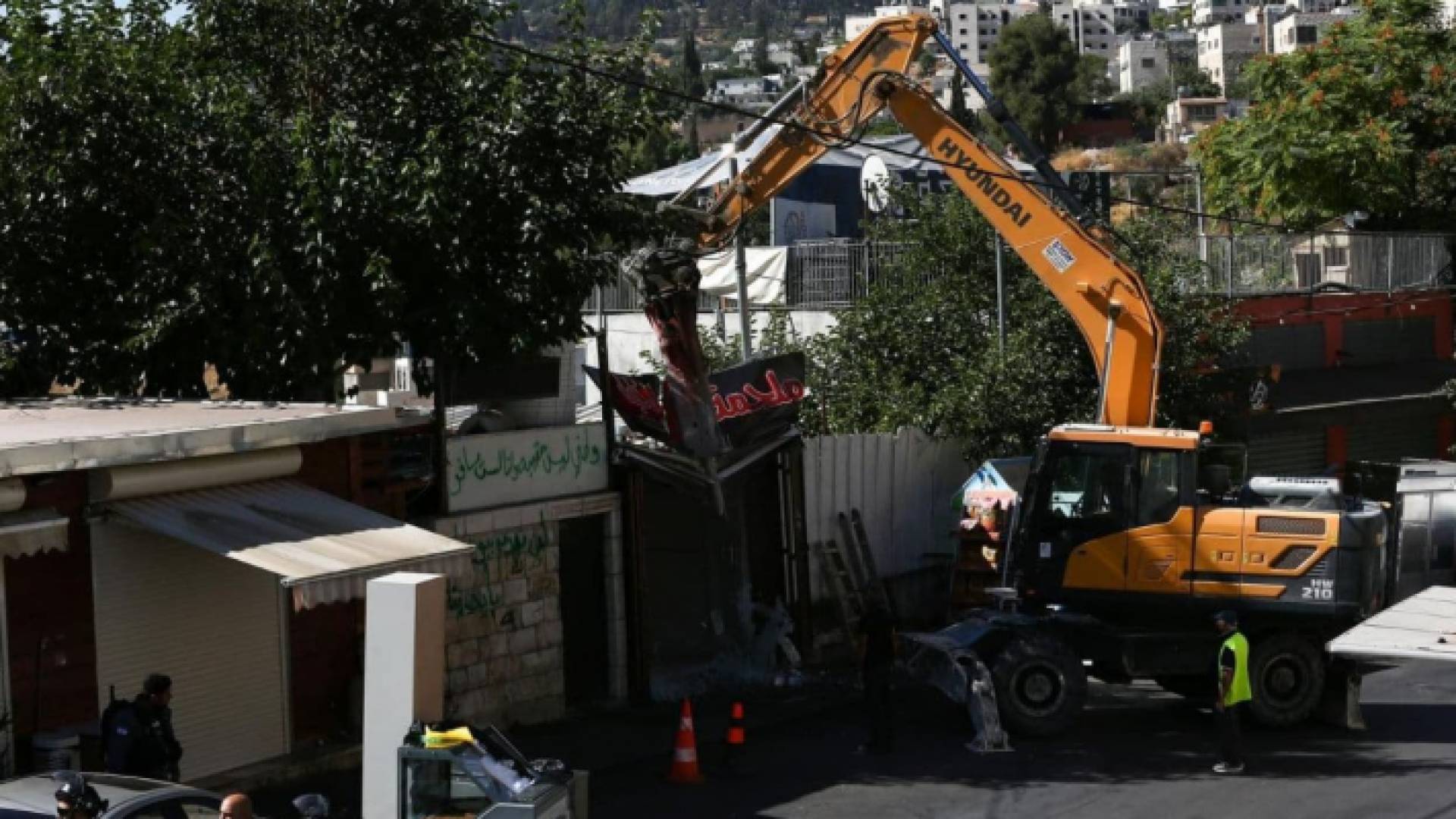 لحظة هدم آليات الاحتلال الإسرائيلي أحد المحلات التجارية في سلوان