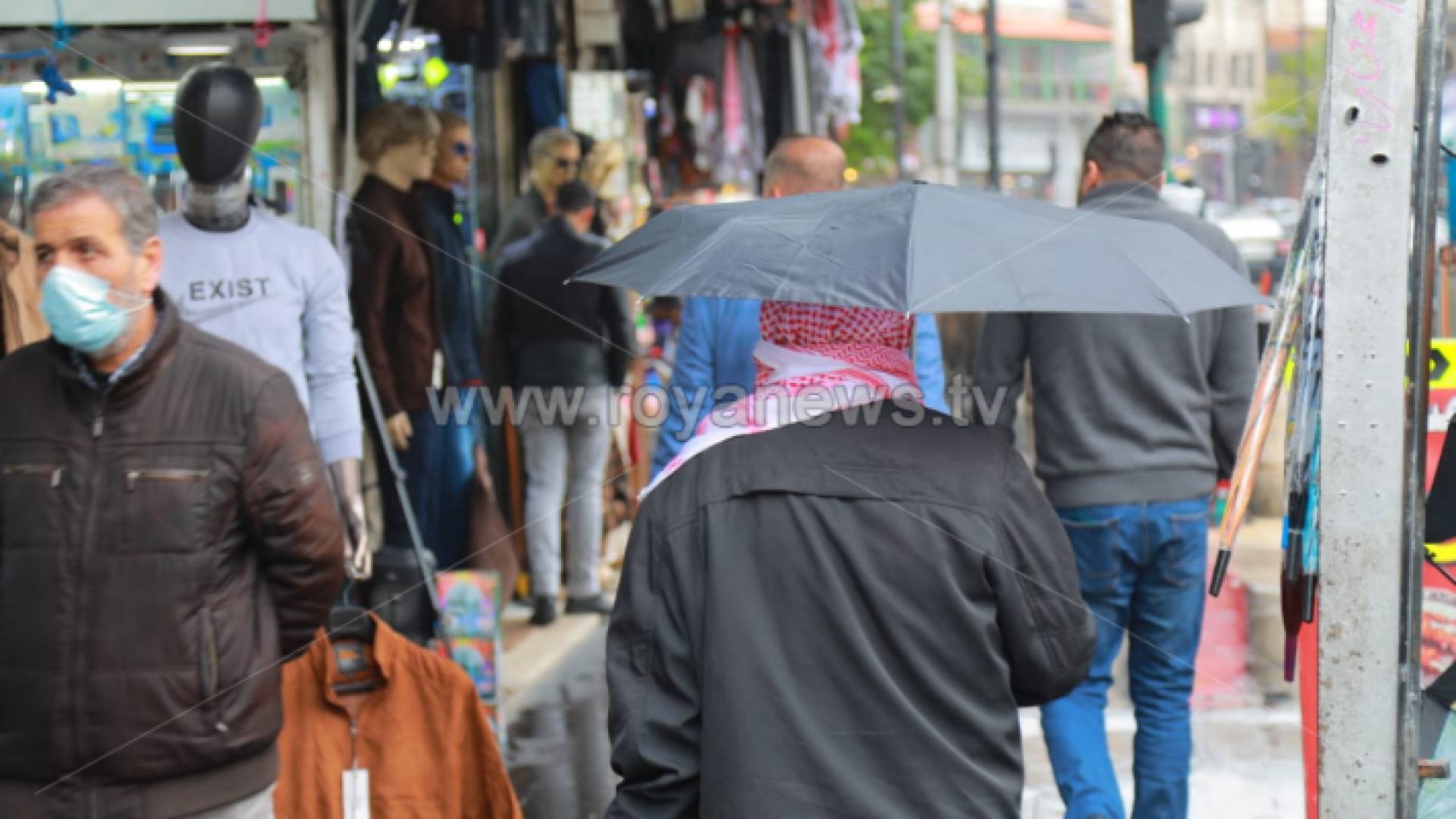 مواطن يحمل مظلية في منطقة وسط البلد