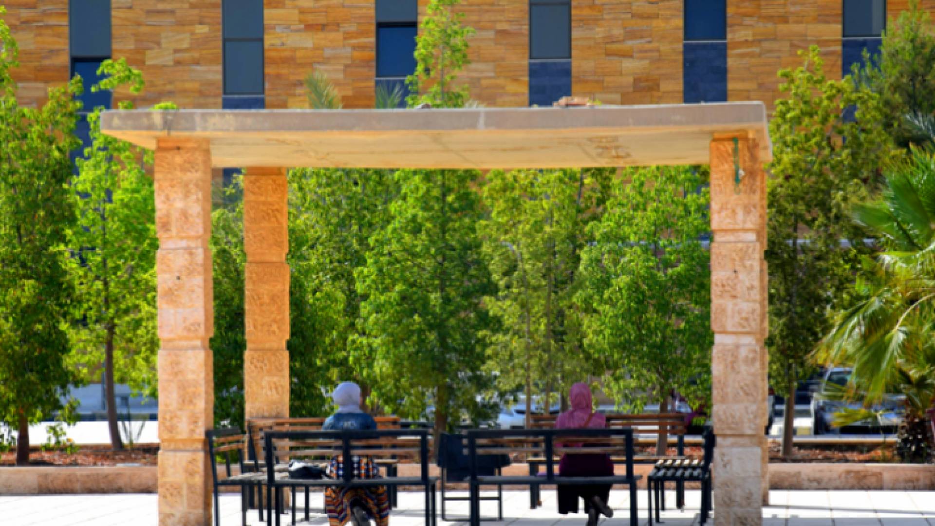 طالبتان تجلسان على مقعد في حرم الجامعة الهاشمية - أرشيفية