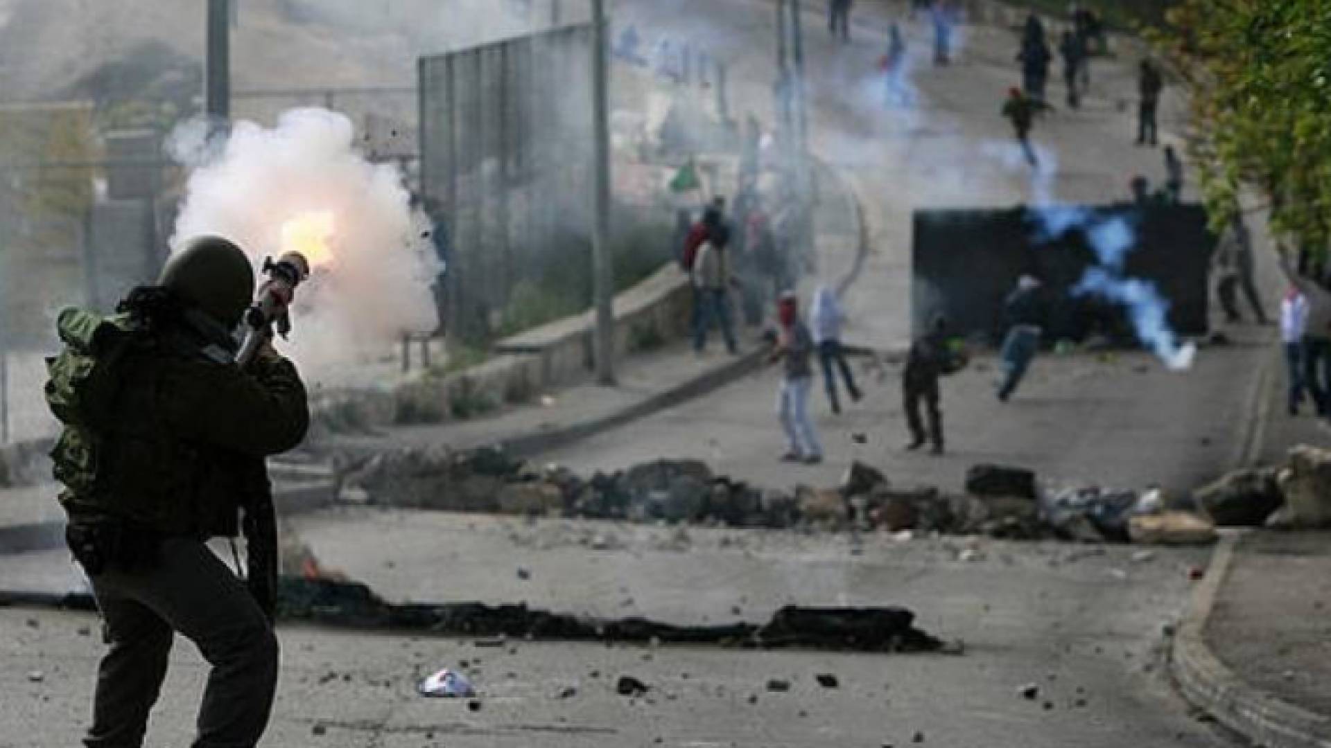 جندي في جيش الاحتلال يطلق الغاز المسيل للدموع على الفلسطينيين في نابلس - أرشيفية
