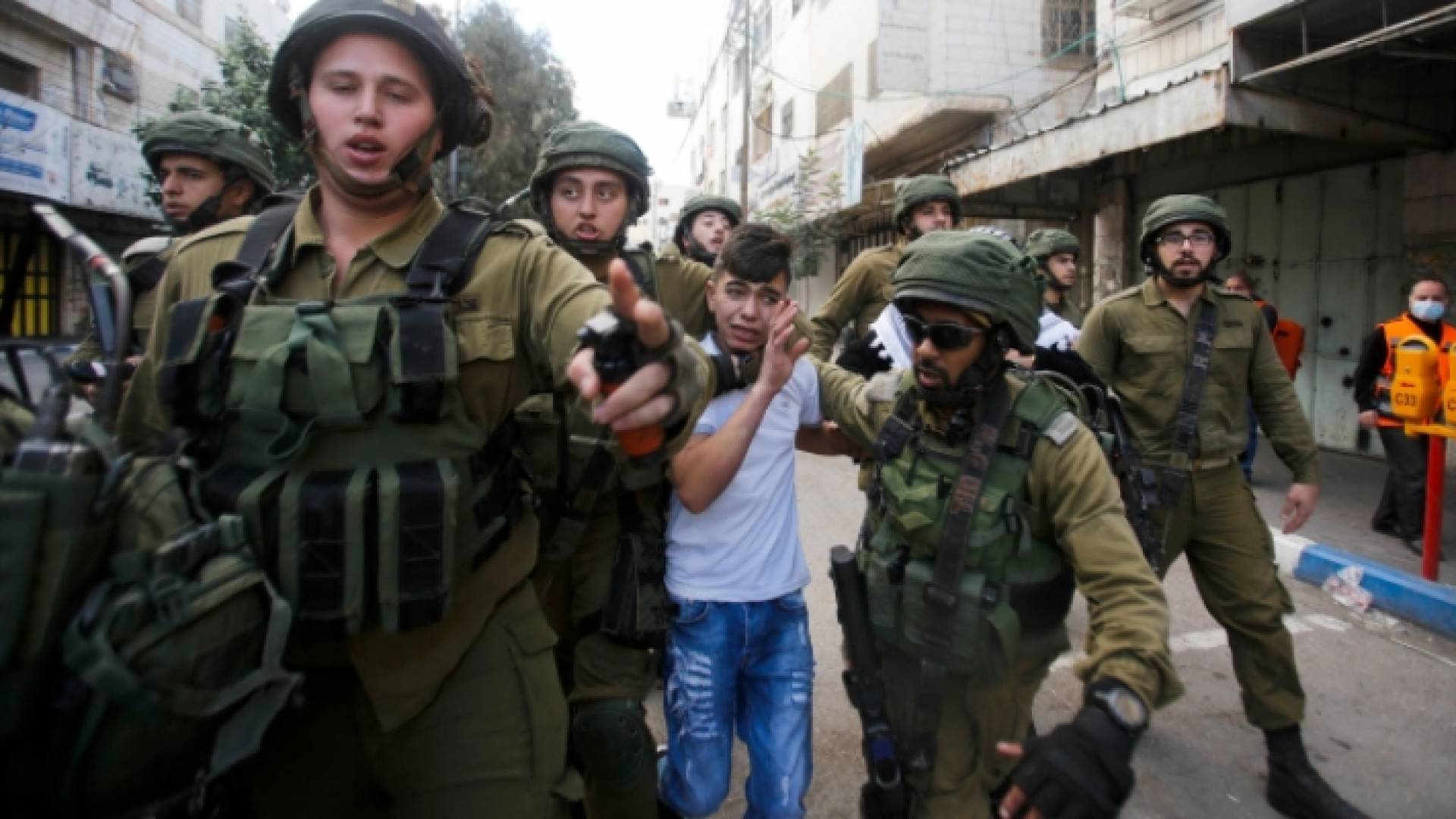 جنود الاحتلال الإسرائيلي يعتقلون طفلا فلسطينيا - أرشيفية