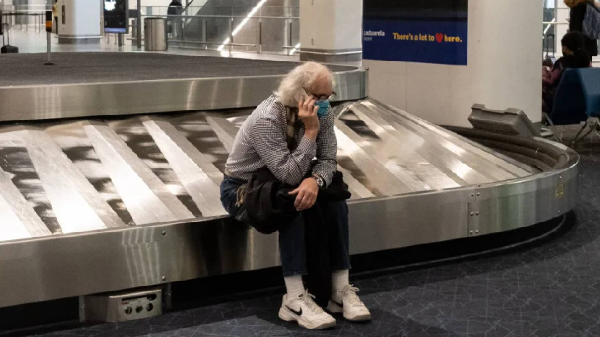 رجل يرتدي كمامة وينتظر وصول حقيبته في احدى المطارات- ا.ف.ب