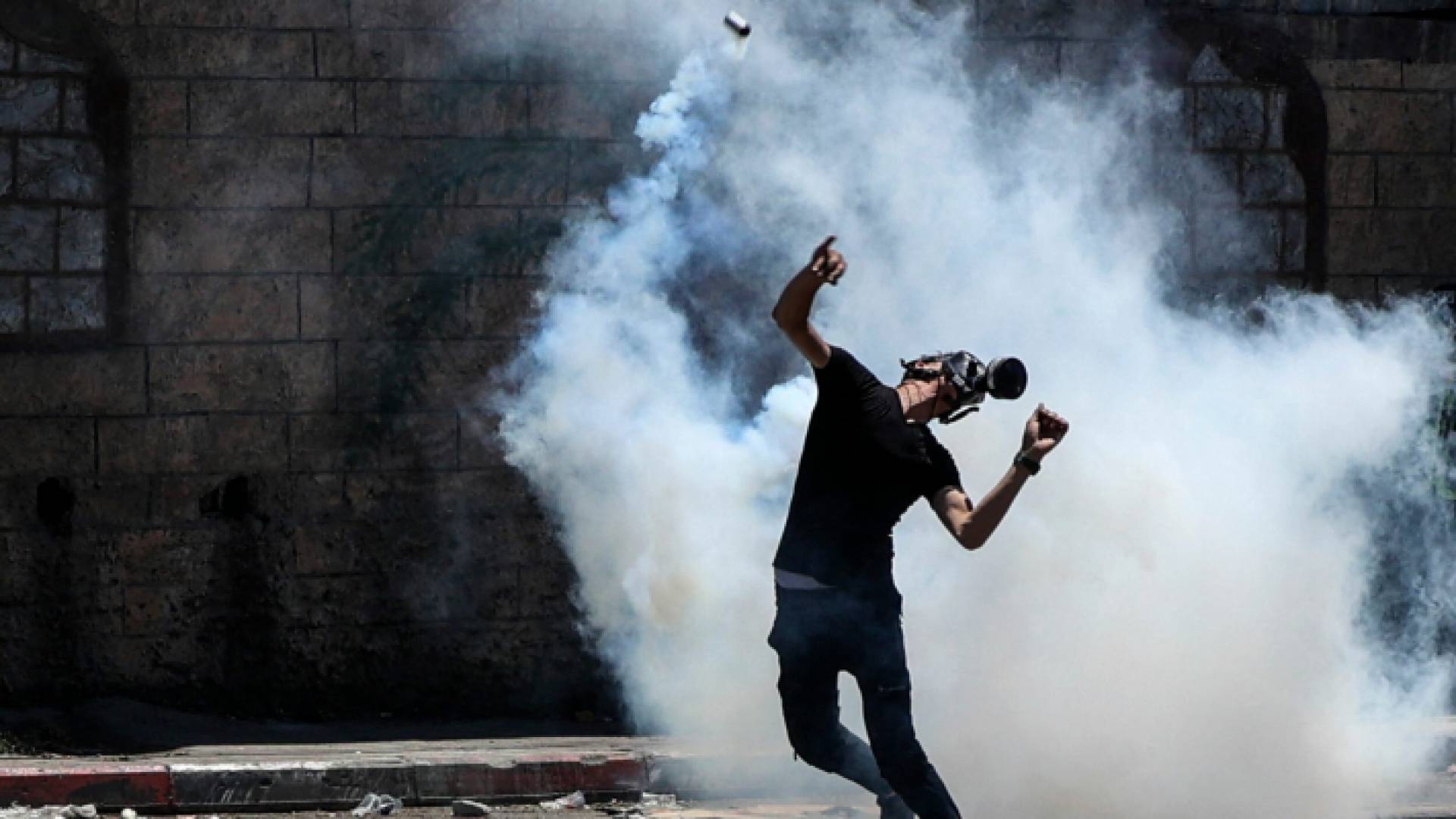 شاب فلسطيني يرتدي قناعا واقيا من الغاز