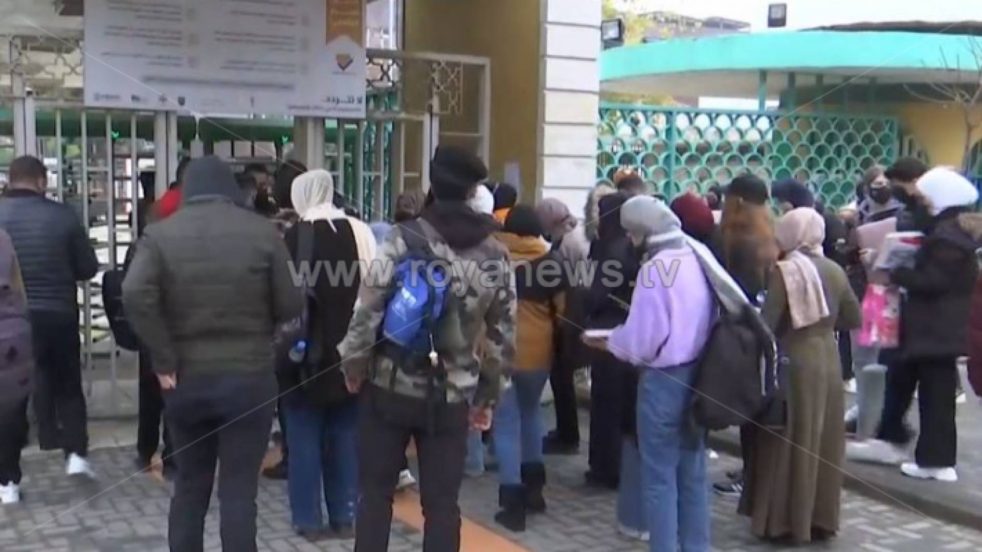 طلبة أمام بوابة الجامعة