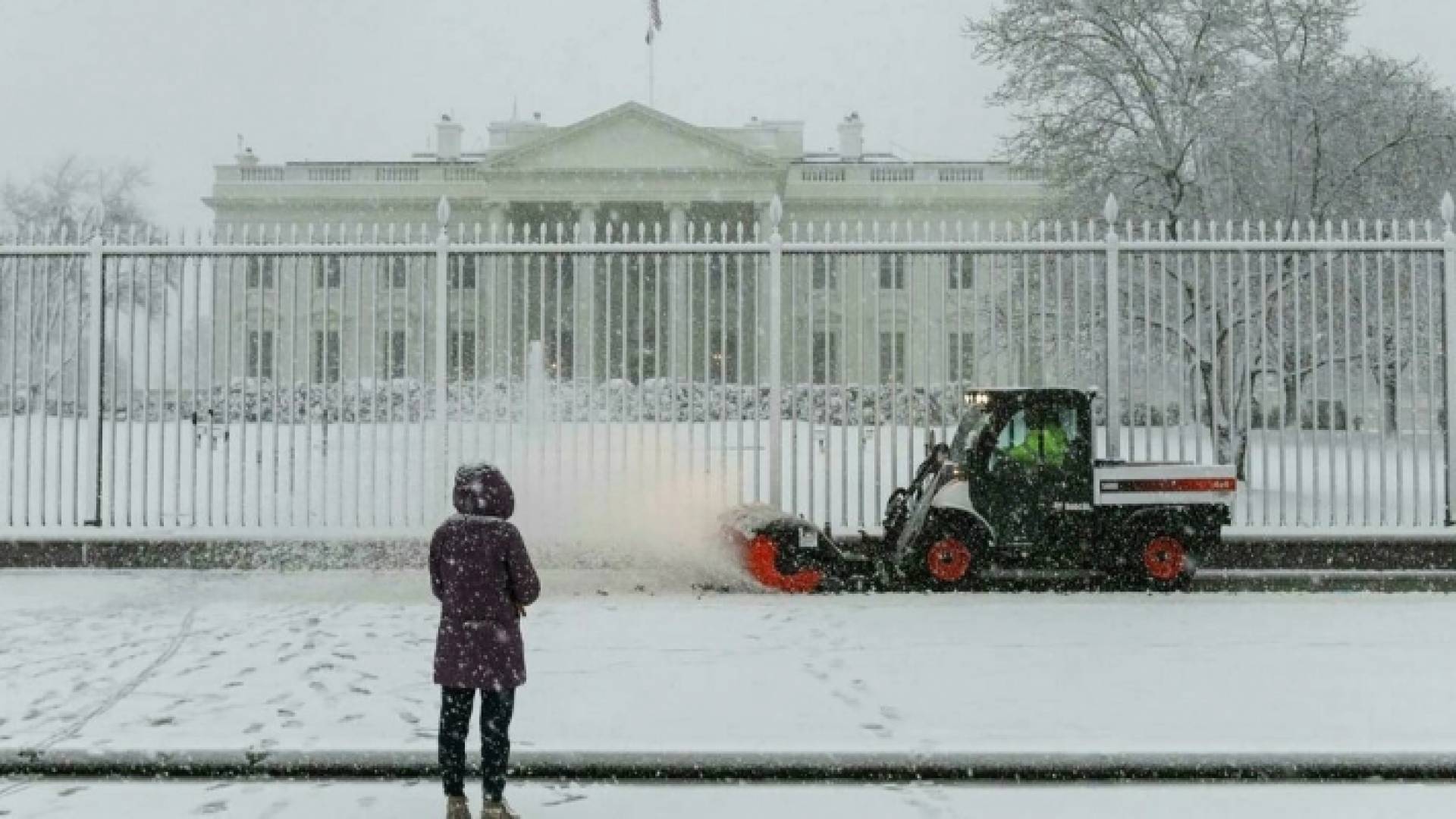 امرأة أمام البيت الأبيض تحت الثلج في واشنطن