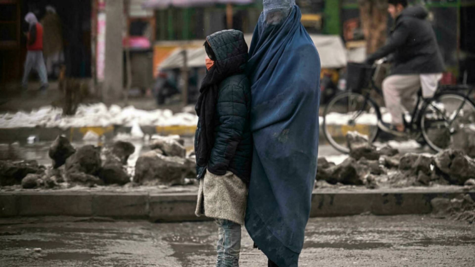 أفغانية تتسول مع طفلة في أحد شوارع كابول- ا ف ب/ارشيف