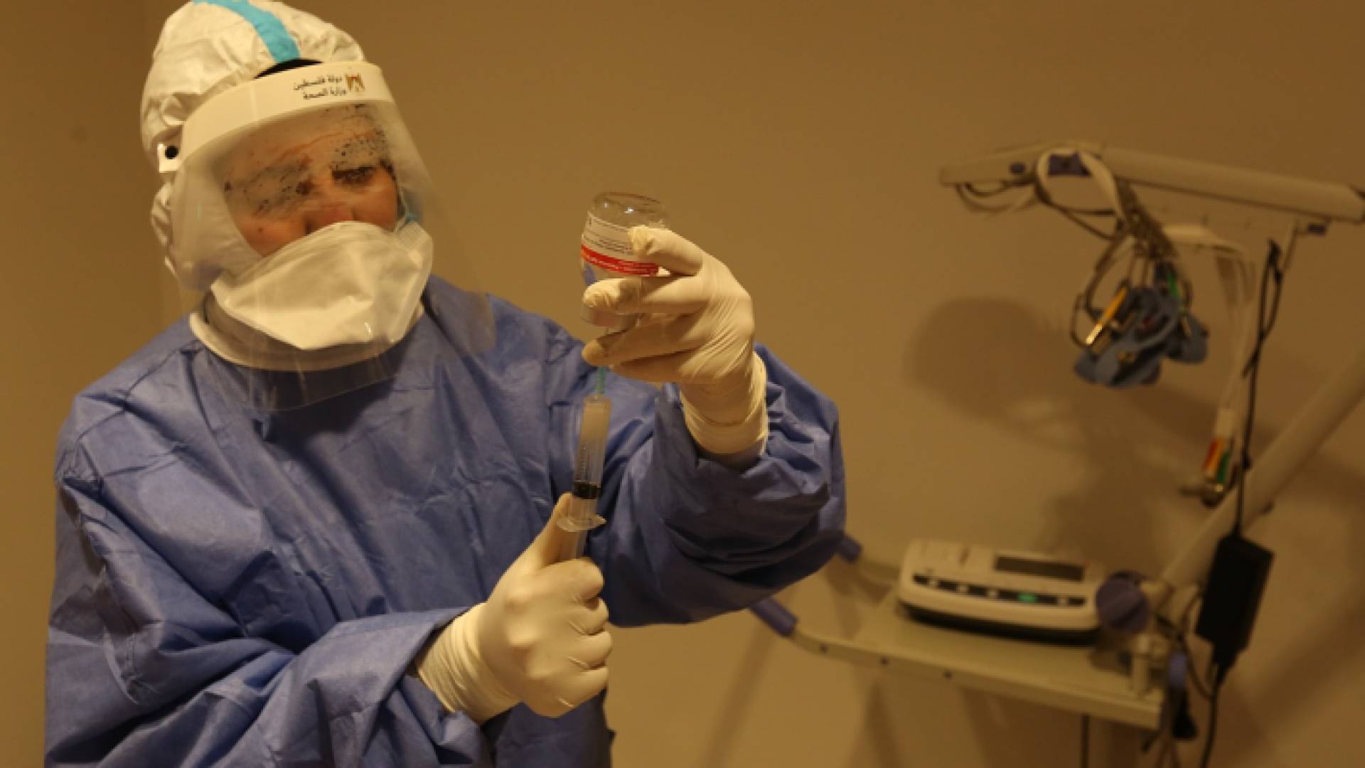 عامل في القطاع الصحي الفلسطيني يحضر جرعة من لقاح كورونا - أرشيفية