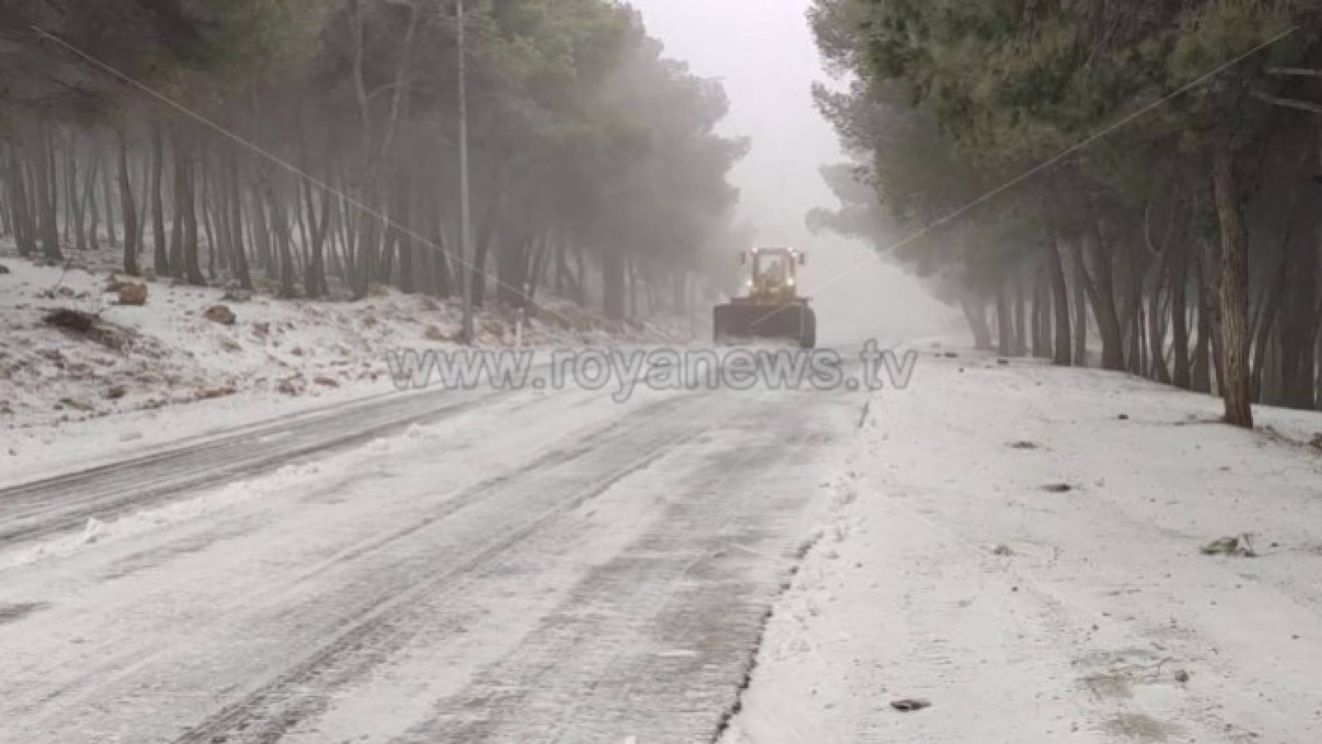 آلية تابعة لبلدية الطفيلة تعمل على فتح طريق مغلق بسبب تساقط الثلوج