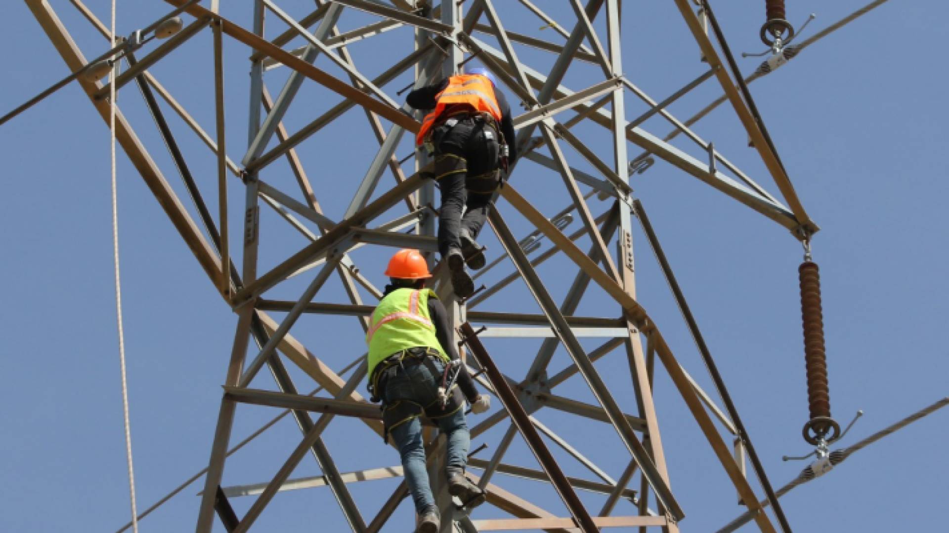 عمال كهرباء ينفذون أعمال صيانة للخطوط - أرشيفية