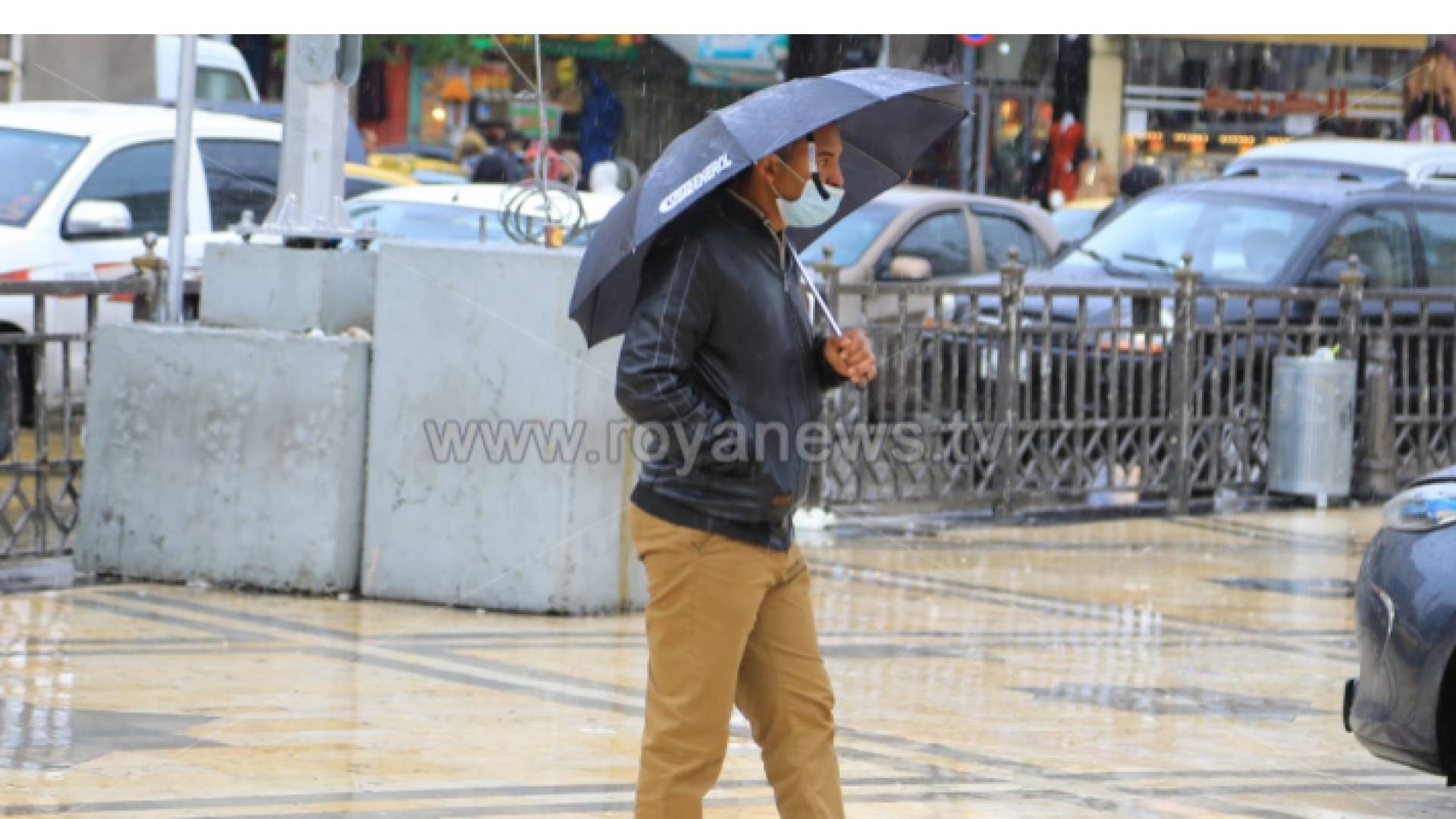 مواطن يحمل مظلة في أحد الشوارع