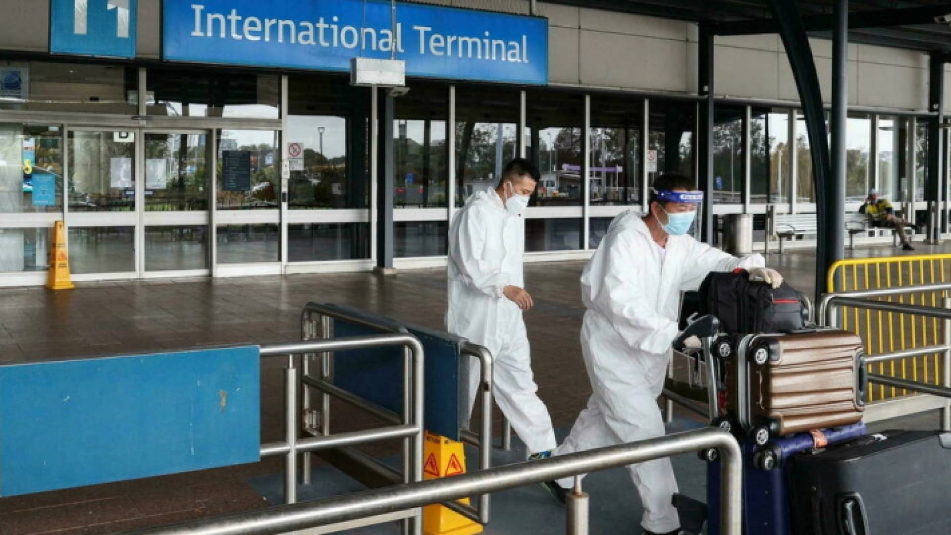 مسافرون يرتدون بزات للحماية الصحية يغادرون المحطة الدولية بمطار سيدني، أستراليا، 29 تشرين الثاني/نوفمبر 2021