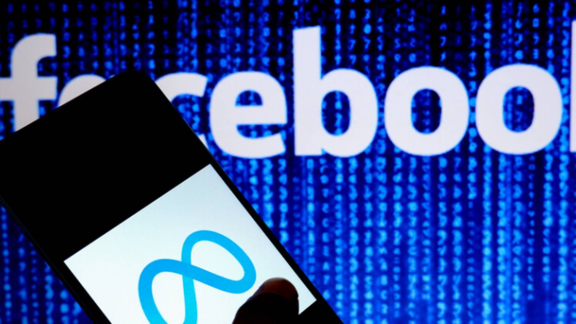 شعار "ميتا" وفي الخلفية شعار "فيسبوك"