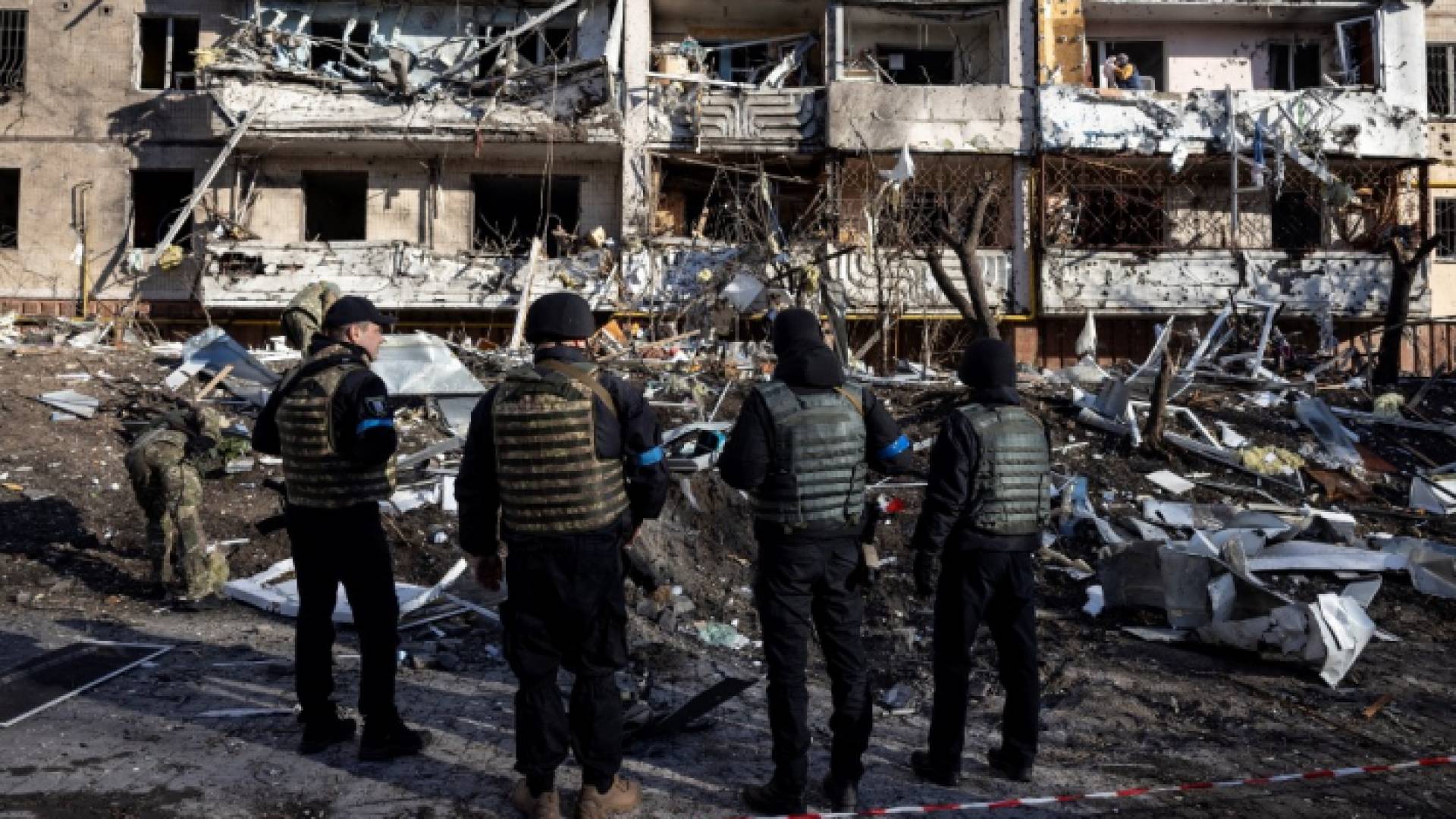 جنود أوكران يقفون بجانب أنقاض مبنى سكني مدمر في كييف في 15 اذار/مارس 2022