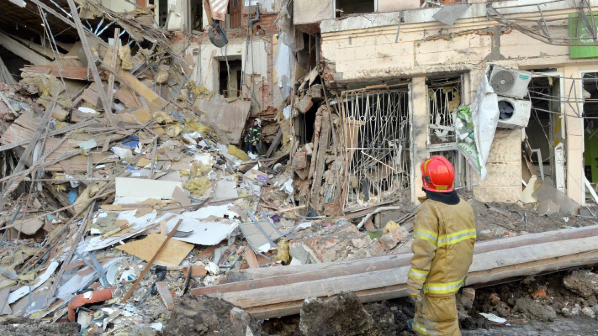 عمال الإنقاذ يزيلون حطام مبنى دمره القصف في وسط خاركيف - AFP