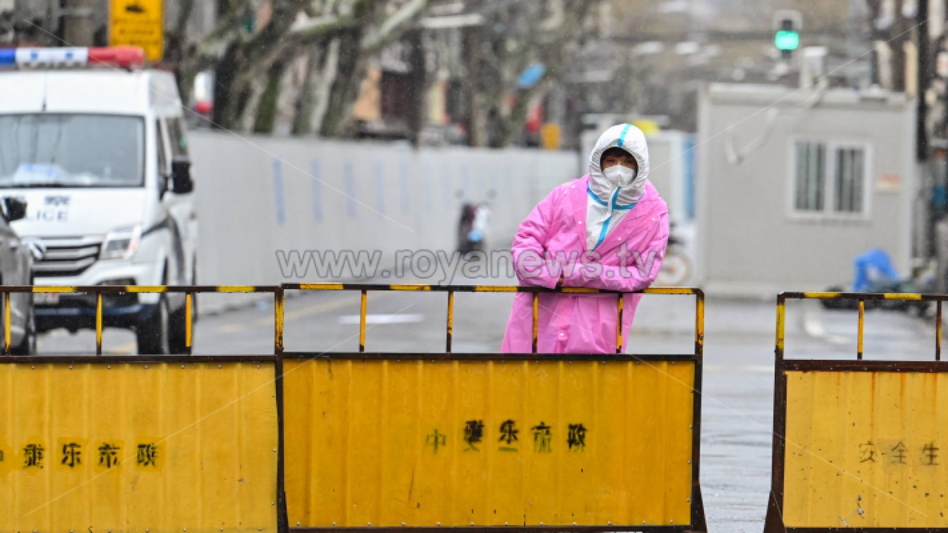 عامل يقف أمام حواجز وضعت لإغلاق أحد الأحياء في شنغهاي