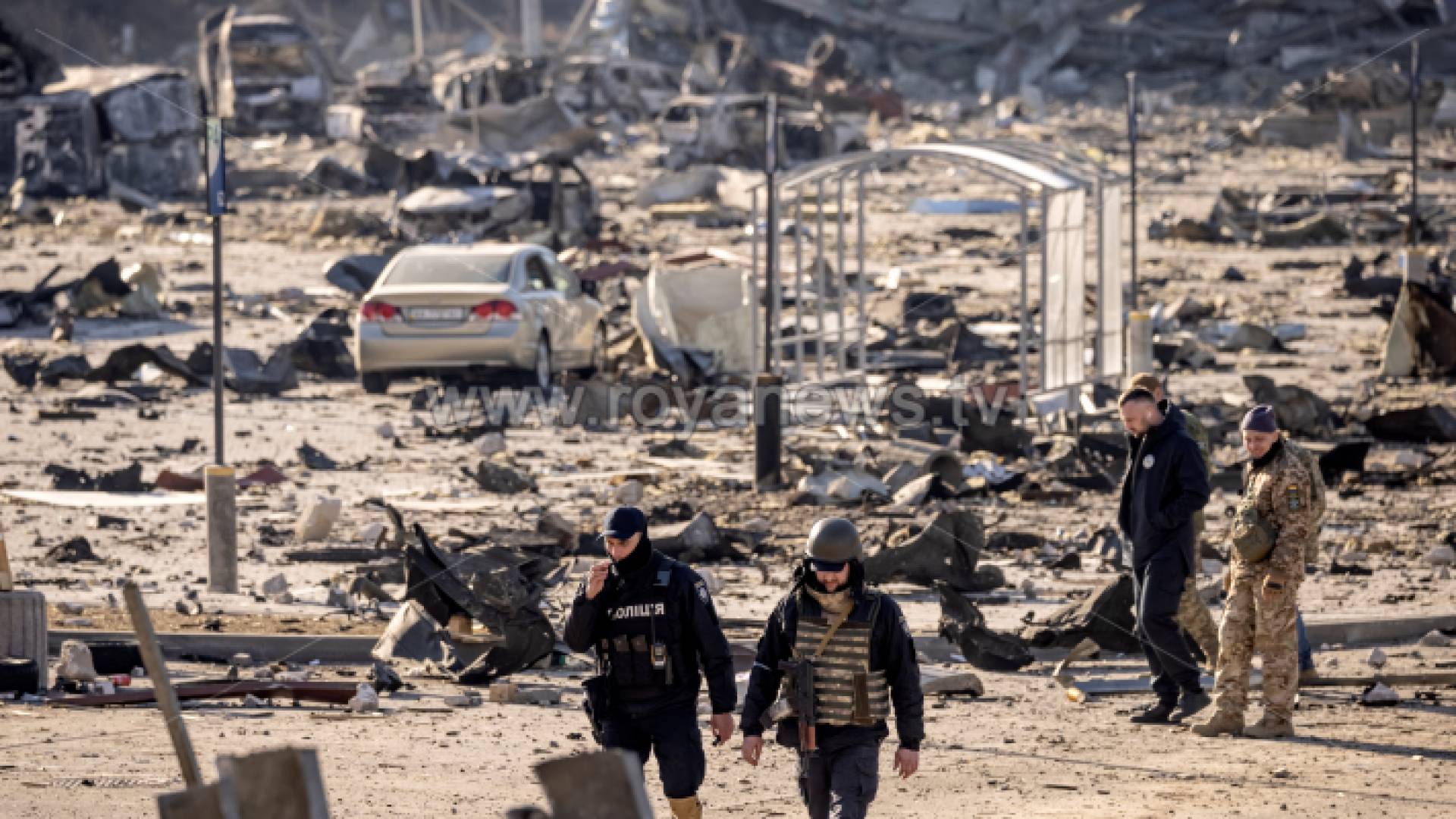 جنود أوكرانيون يسيرون وسط أنقاض مركز للتسوق بعد يوم من قصفه من قبل القوات الروسية في كييف