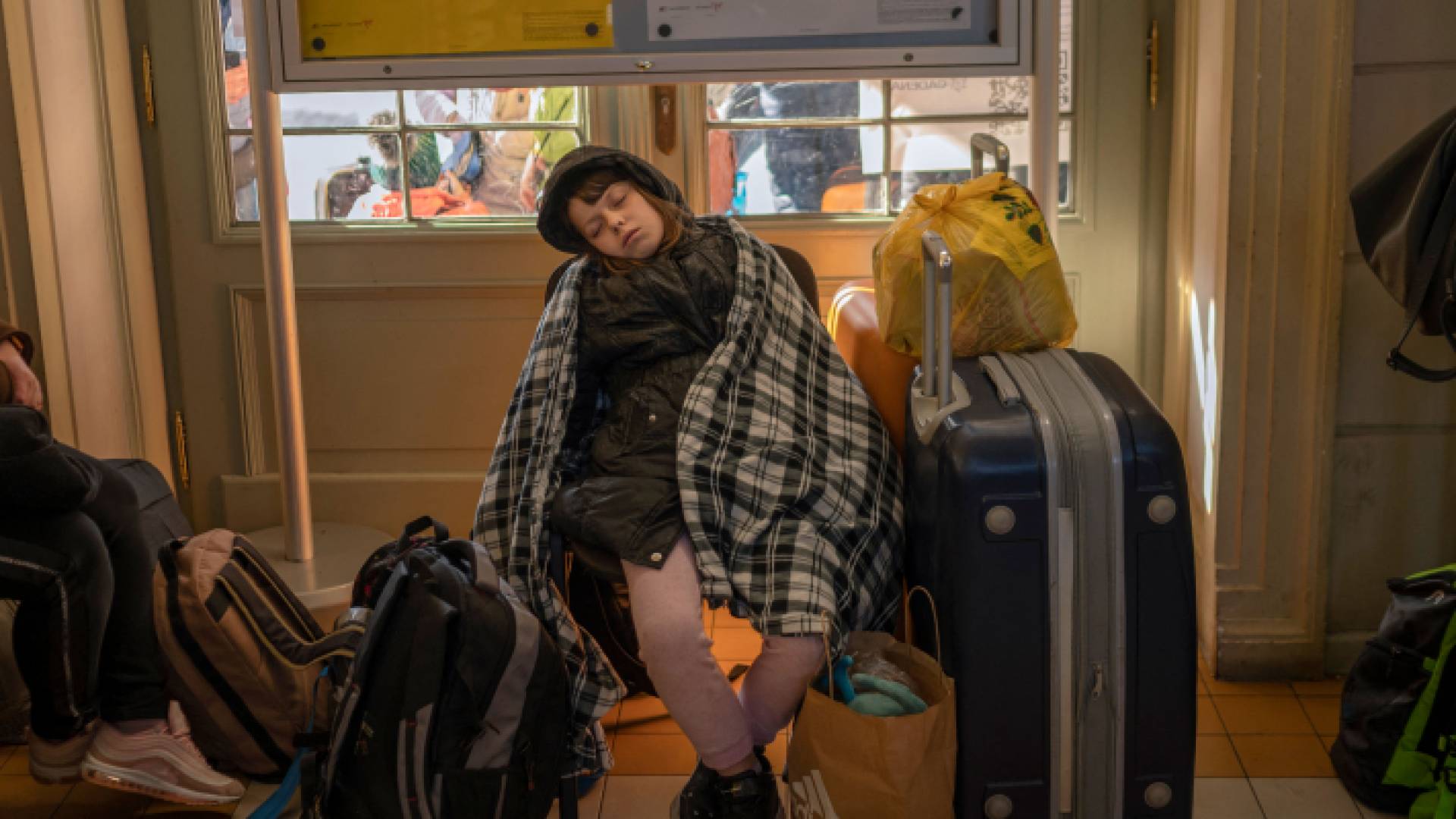 فتاة تنام بجوار حقائب سفر بينما ينتظر لاجئون من أوكرانيا في محطة السكك الحديدية الرئيسية جنوب شرق بولندا