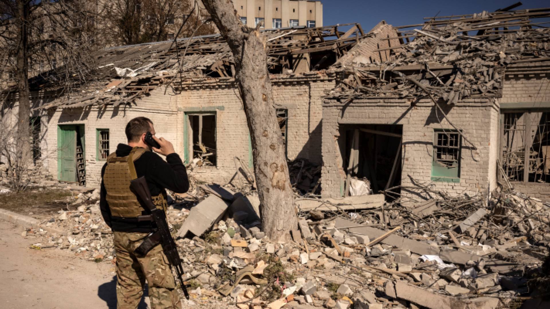 جندي أوكراني يقف إلى جانب منزل تدمر جراء الحرب
