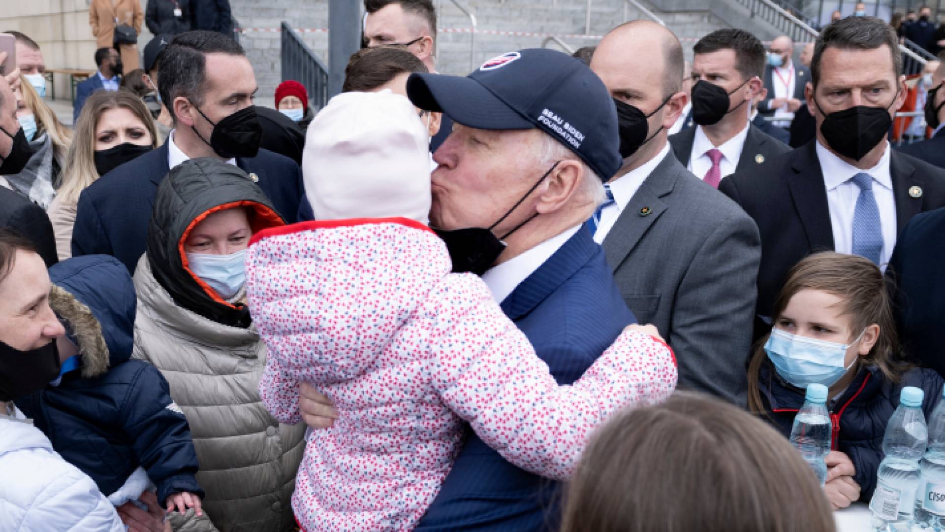 الرئيس الأمريكي جو بايدن يقبل طفلا أثناء لقائه باللاجئين الأوكرانيين في بولندا