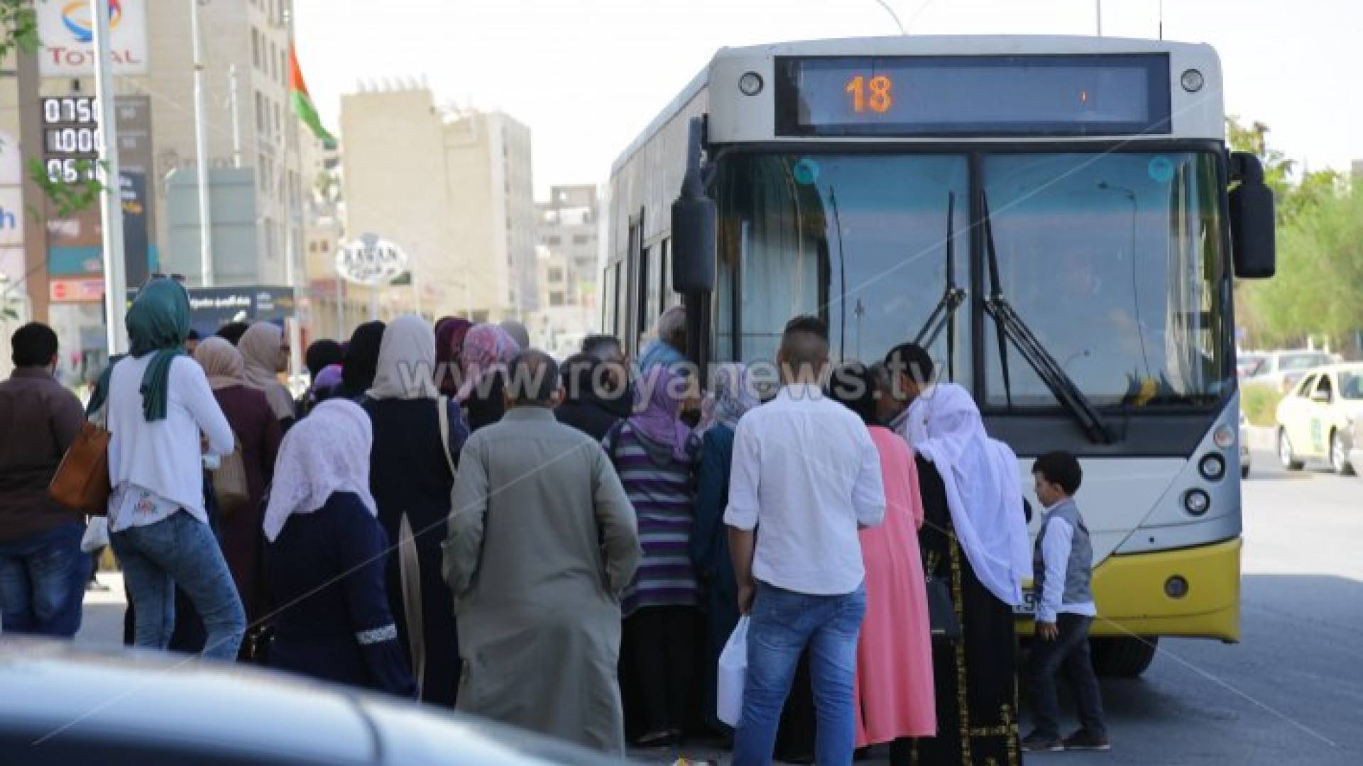 مواطنون امام إحدى حافلات النقل العام