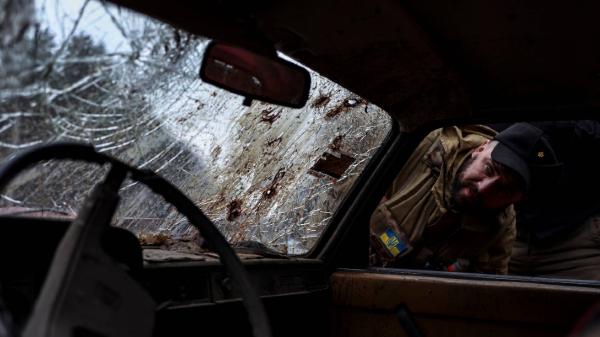 جندي أوكراني يتفقد مركبة تعرضت لقصف