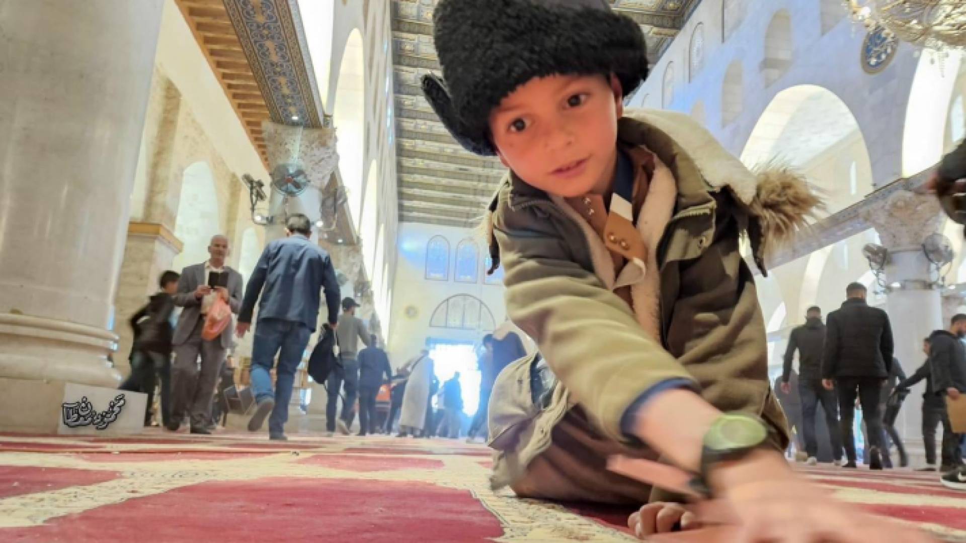 طفل يشارك بتنظيف سجاد المسجد الاقصى