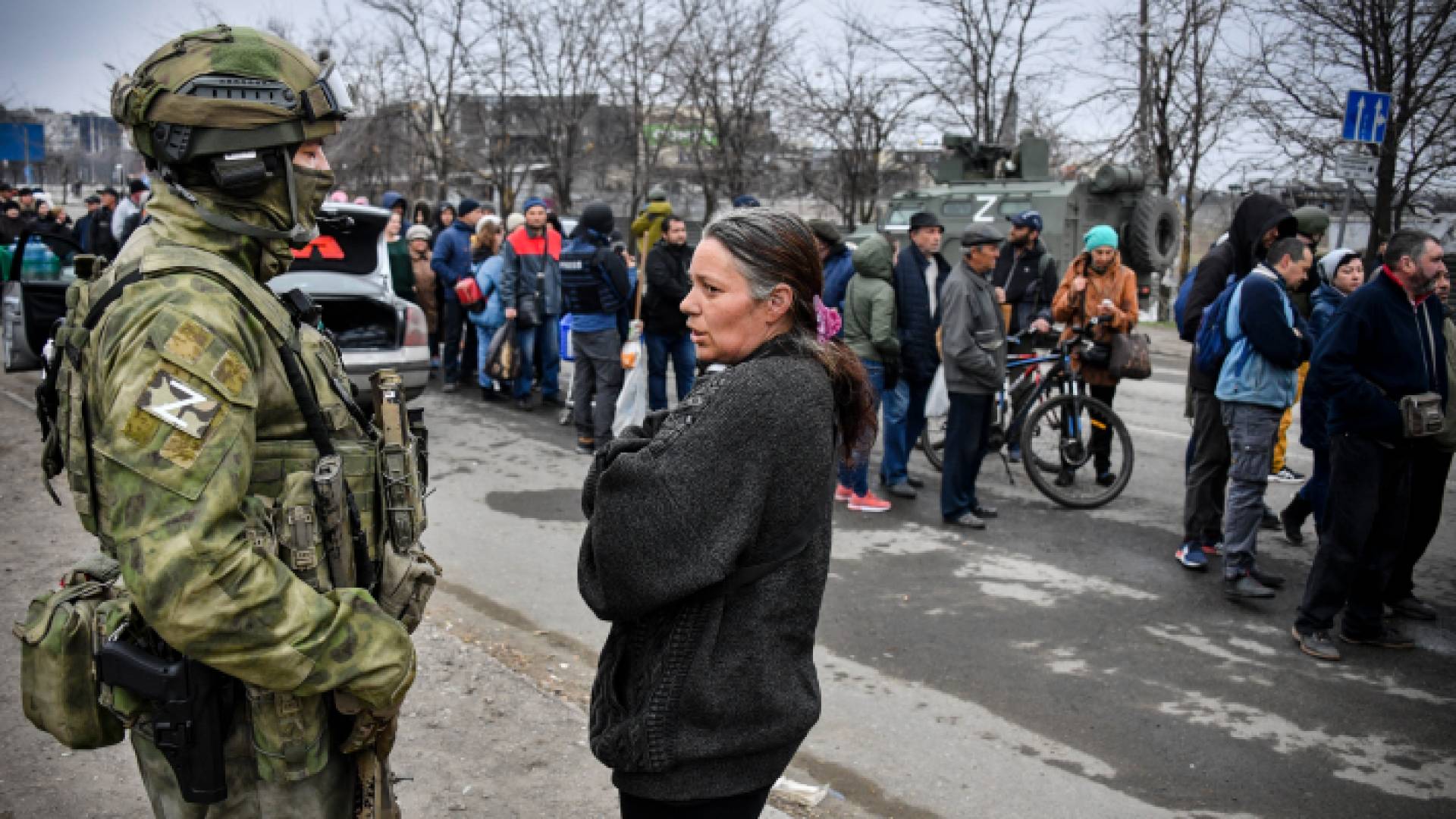 جندي روسي يتحدث إلى مواطنة أوكرانية
