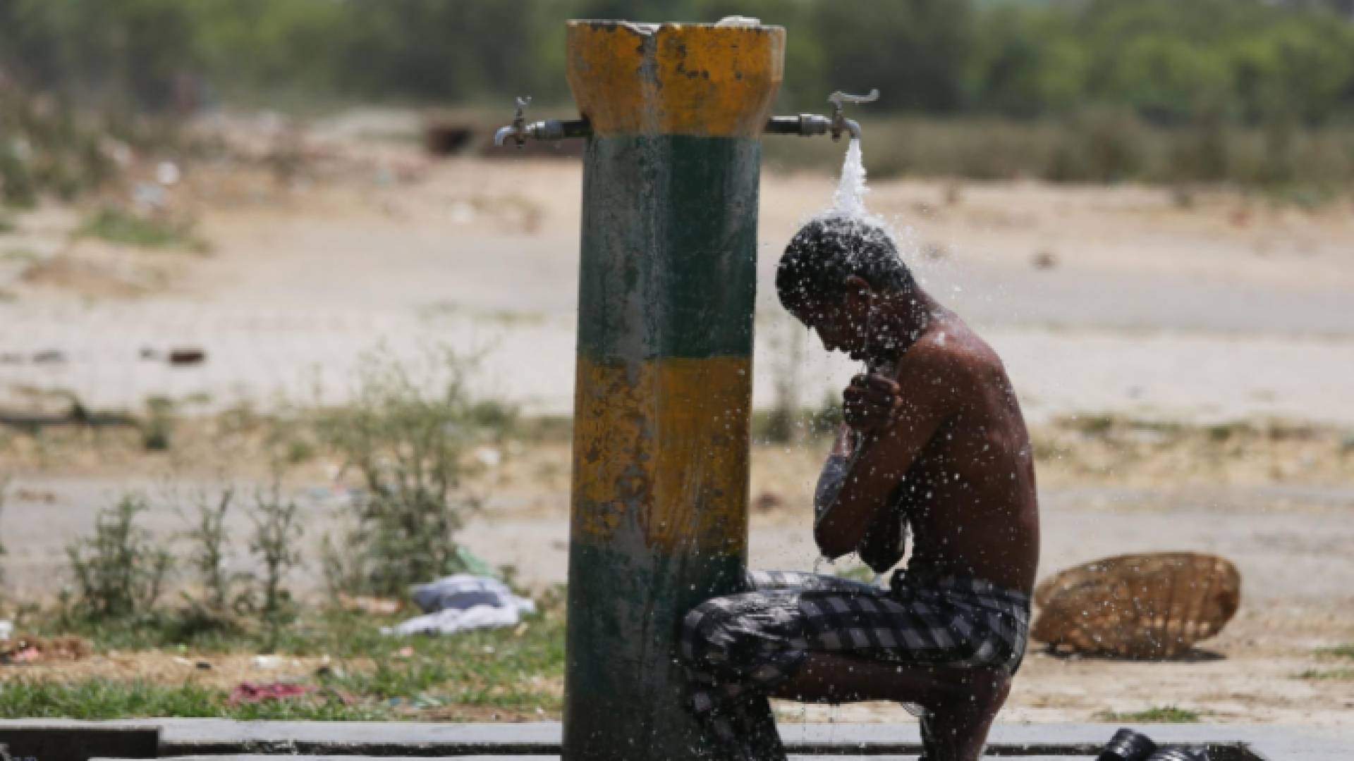 هندي يستحم بالماء وسط الشارع بسبب ارتفاع درجات الحرارة