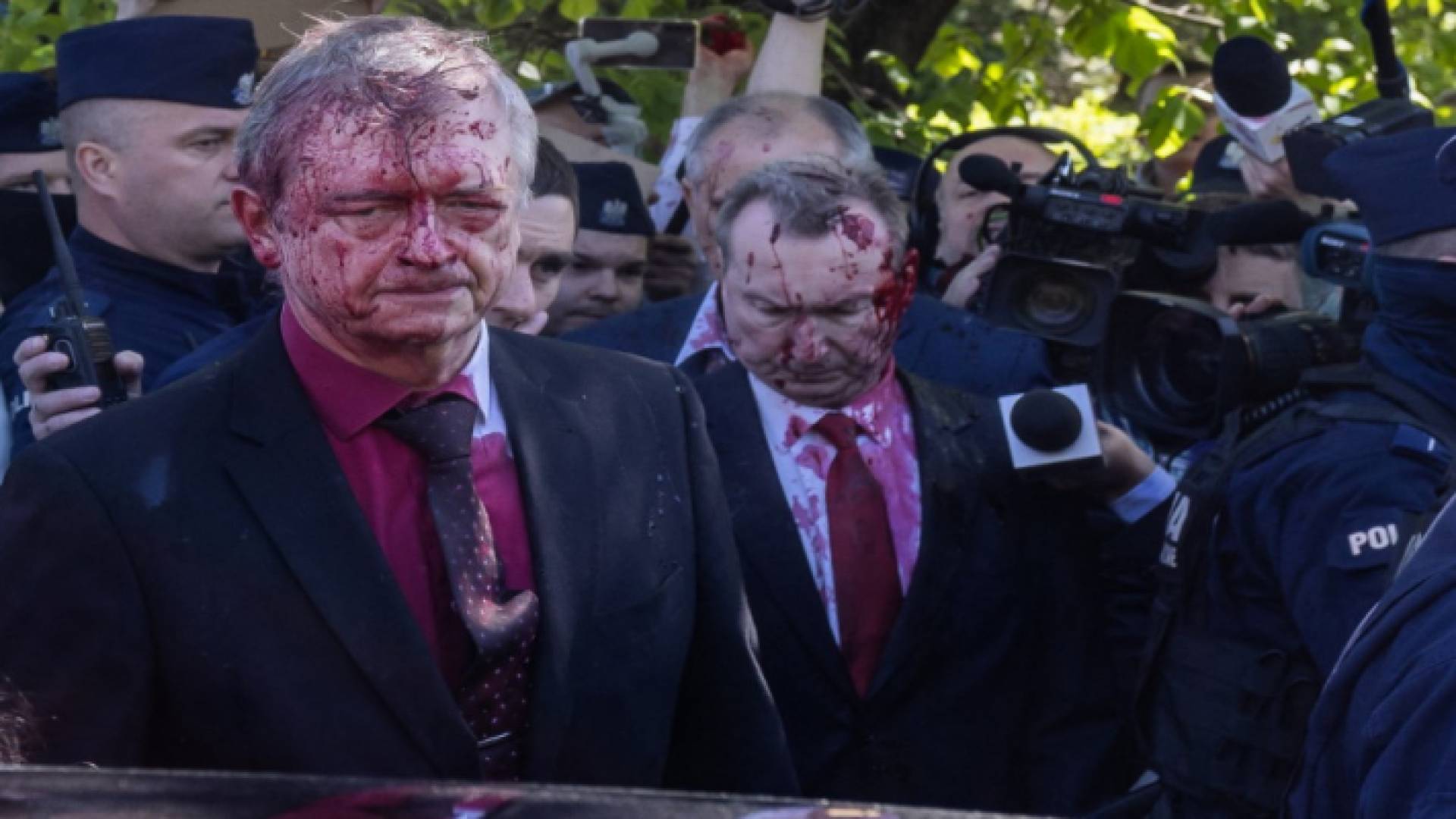 السفير الروسي لدى بولندا سيرجي أندرييف (يسار) يستقل سيارته بعد تغطيته بالطلاء الأحمر في حفل وضع إكليل من الزهور في ضريح حرب الجندي السوفيتي في وارسو