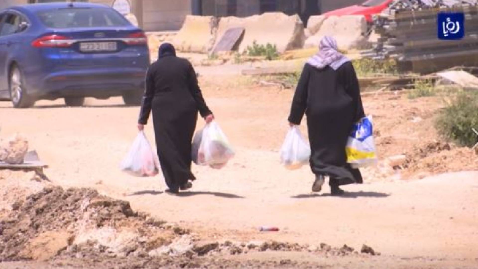 سيدتان تسيران على طريق ترابية