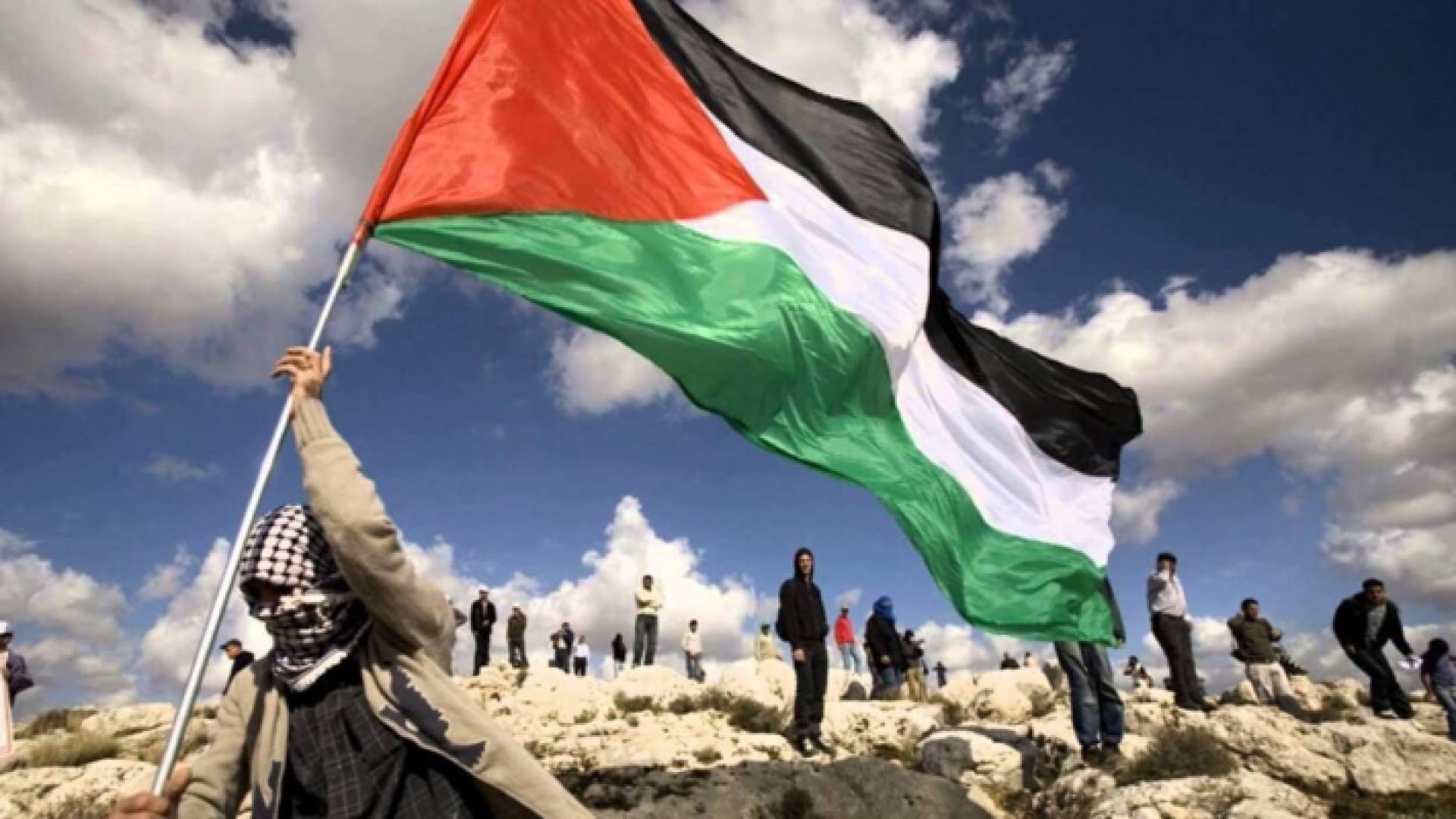 شاب فلسطيني يرفع العلم الفلسطيني