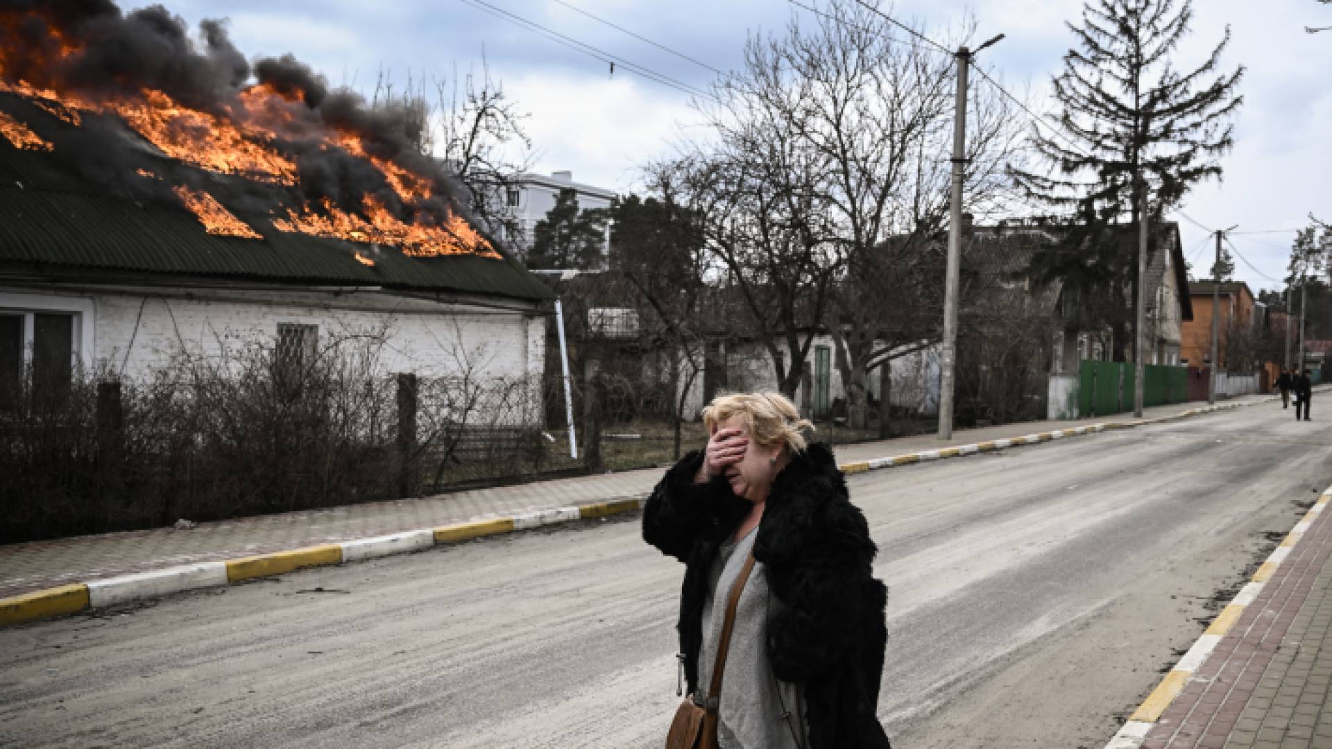 سيدة أوكرانية تقف أمام منزل تعرض لقصف روسي