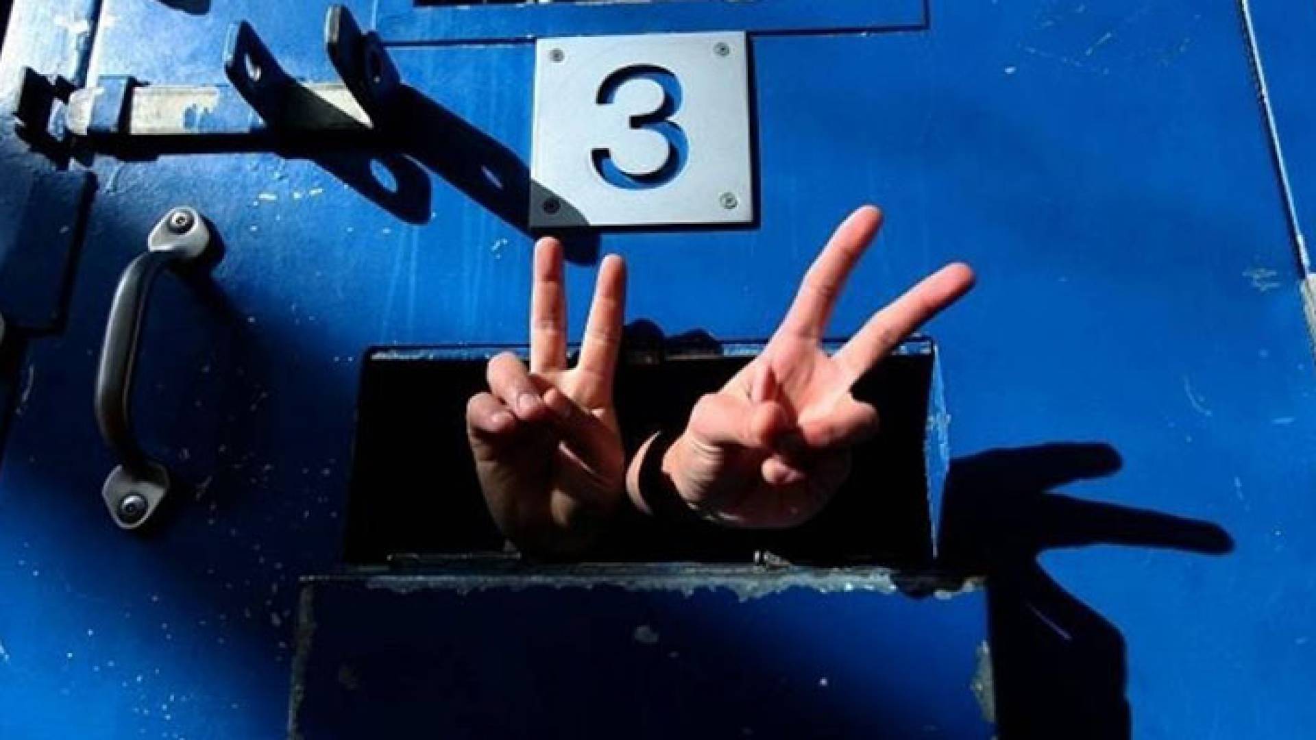 أسرى فلسطينيون يلوحون بإشارة النصر من داخل أحد معتقلات الاحتلال الإسرائيلي