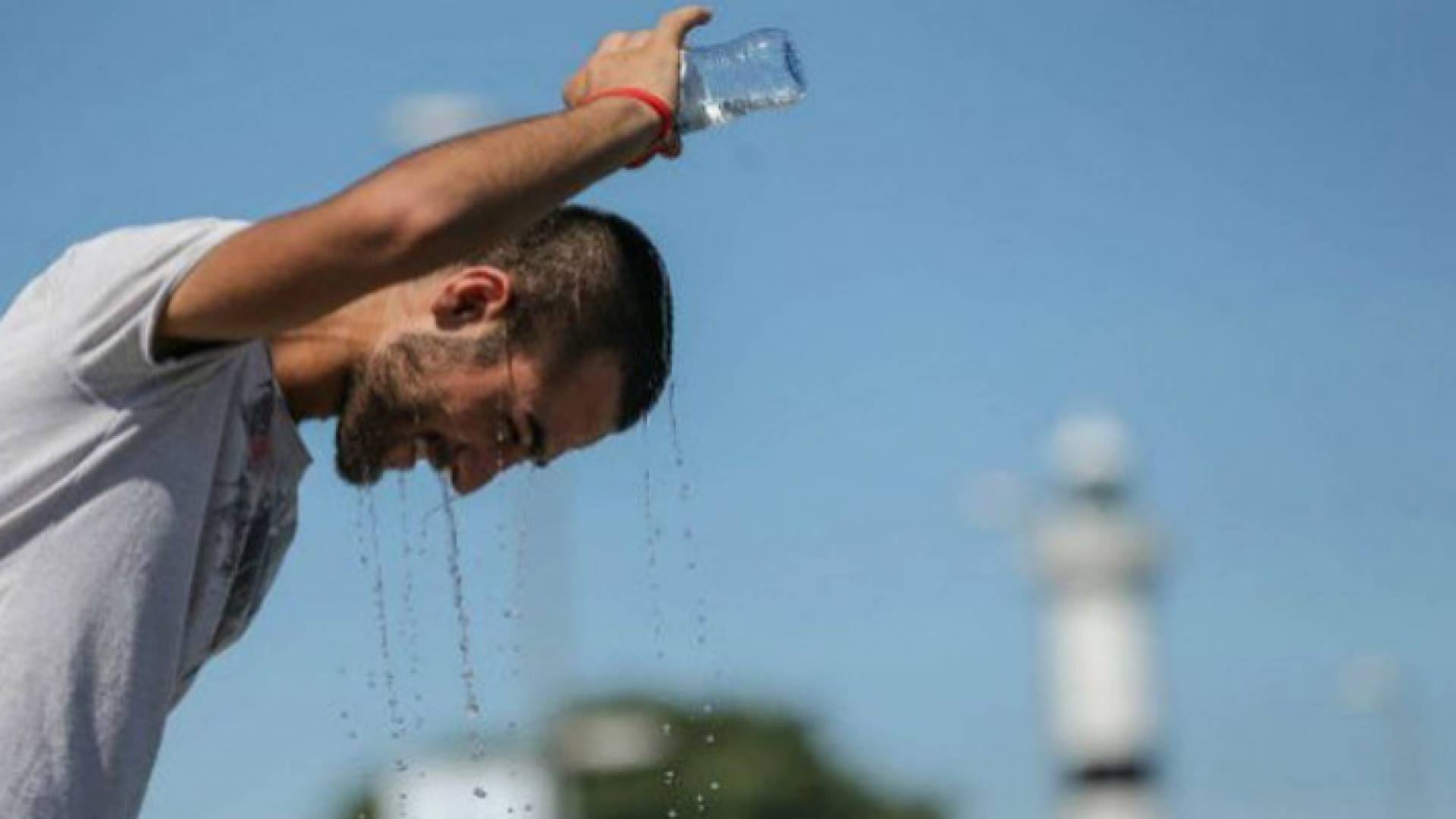 شخص يسكب الماء على رأسه للتخفيف من شدة حرارة الطقس في العاصمة عمان