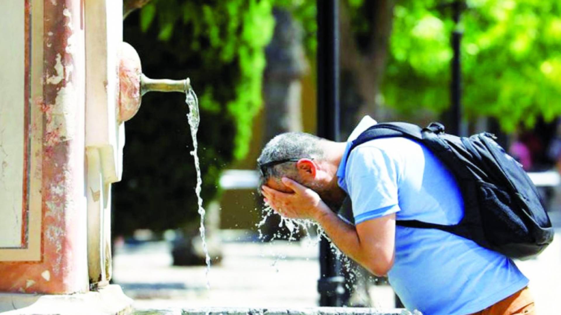 شخص يغسل وجهه في الماء للتخفيف من حرارة الطقس في فرنسا